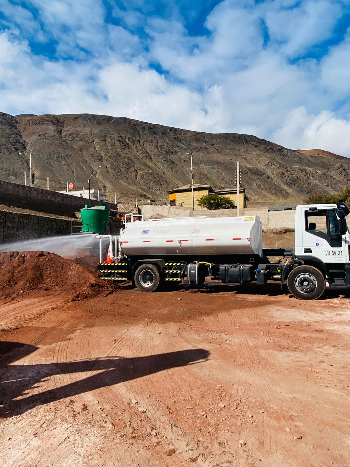 Camión aljibe efectuando humectación del terreno en la cancha de futbolito de Taltal.