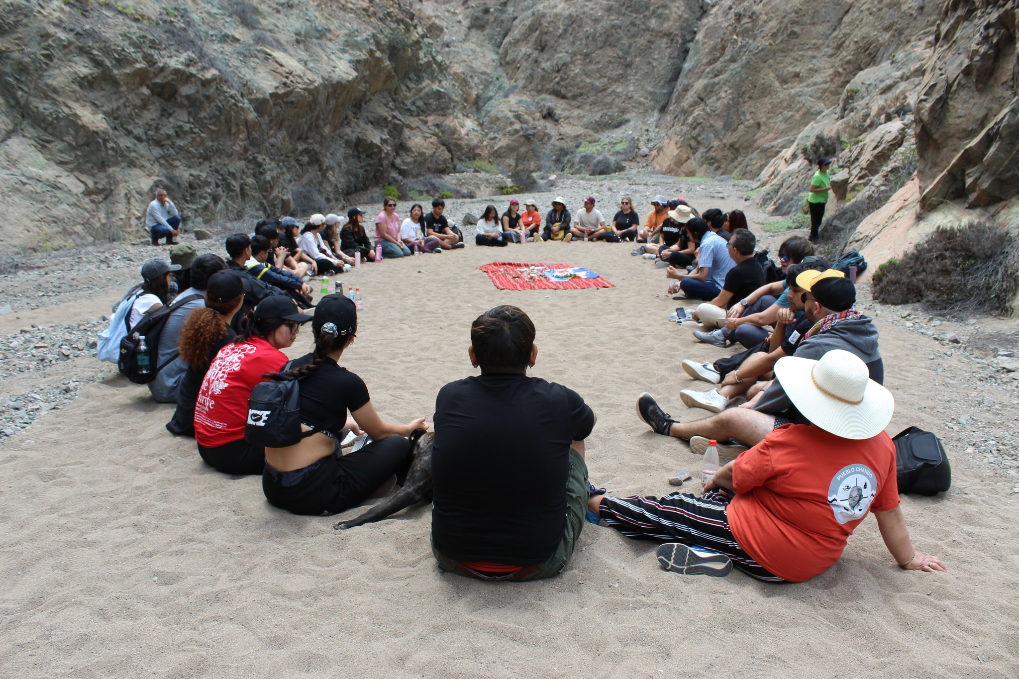 Participantes de la Segunda Jornada Regional de Medicina Ancestral Changa reunidos en círculo en una quebrada de Taltal.