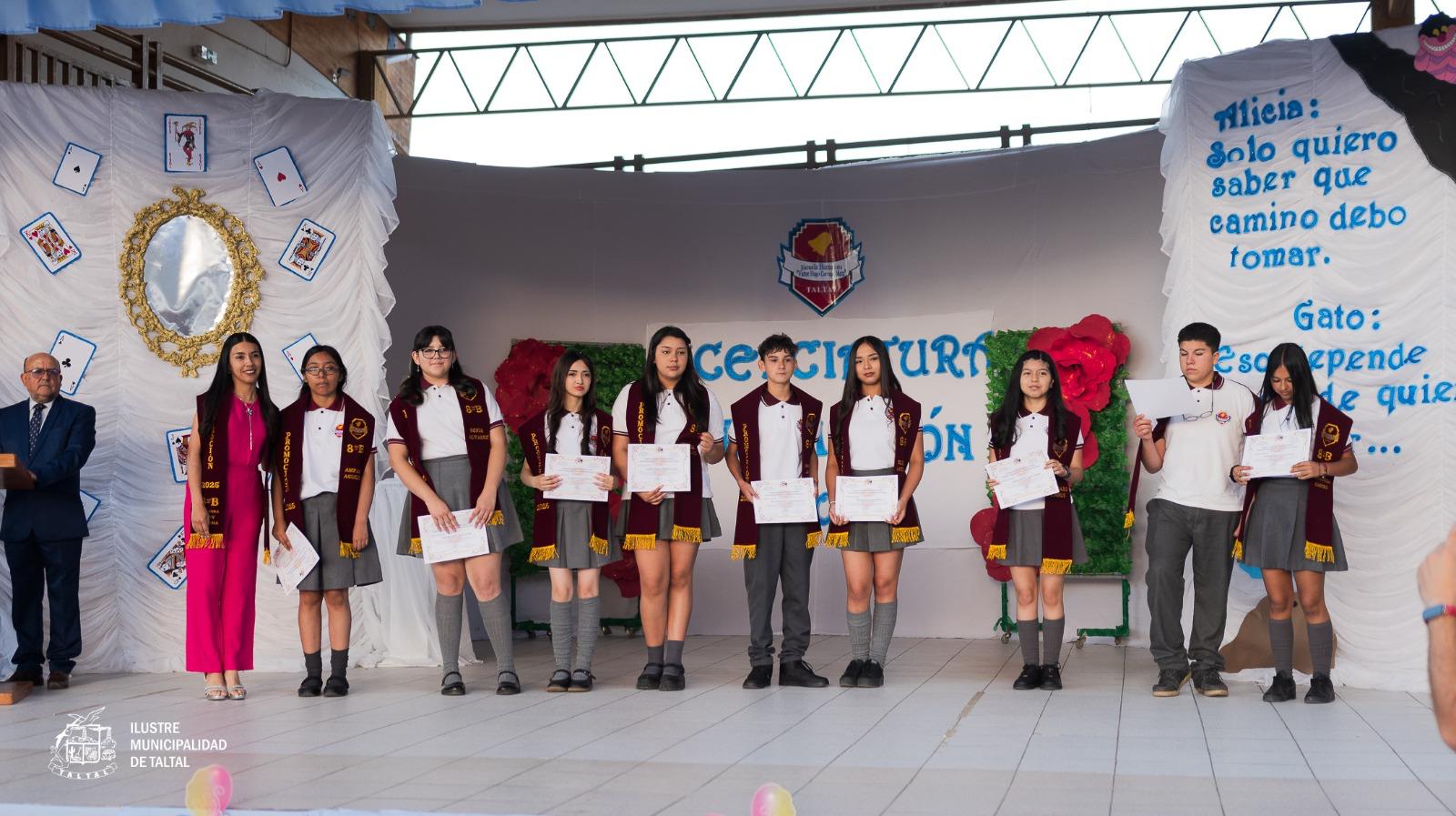 Fila de alumnos de la promoción 2025 posando con sus estolas y diplomas en el acto final.