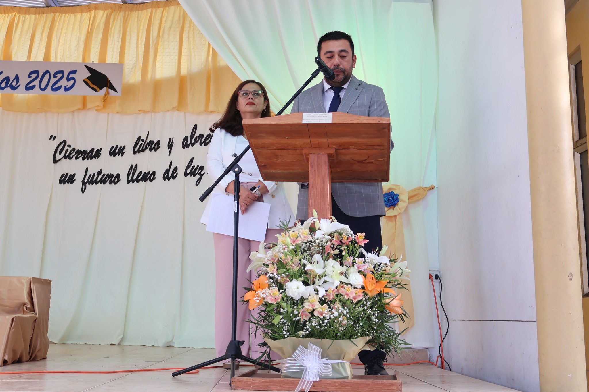 Discurso en podio durante ceremonia de despedida de sextos básicos 2025.