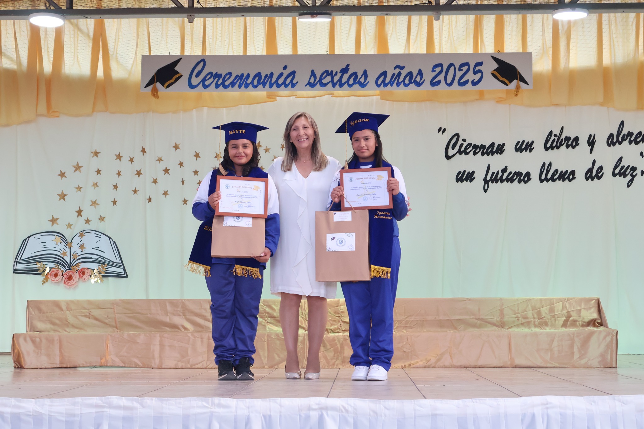 Estudiantes reciben reconocimiento y posan con docente en ceremonia 2025.