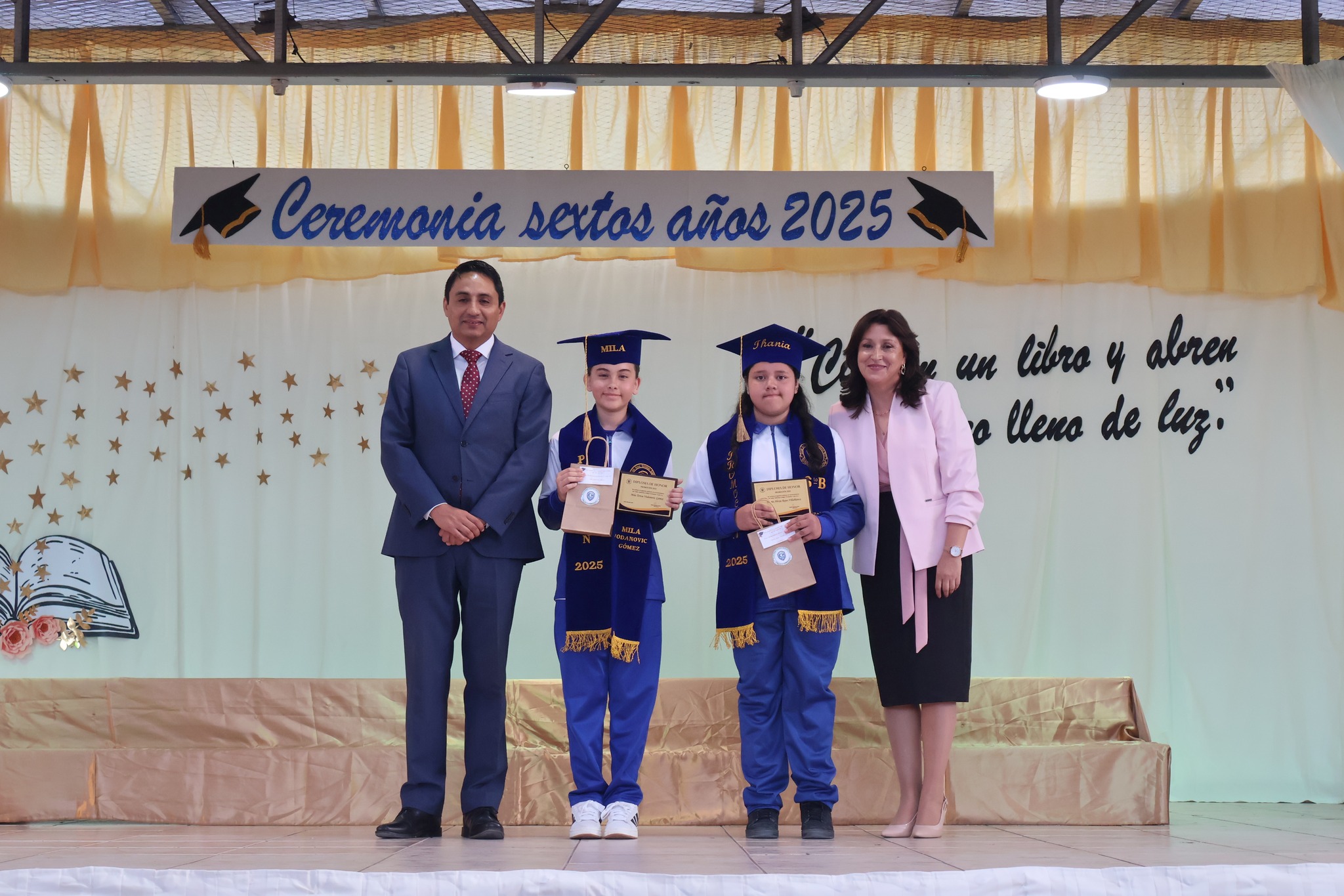 Estudiantes con certificados y autoridades posan en el escenario de la ceremonia 2025.