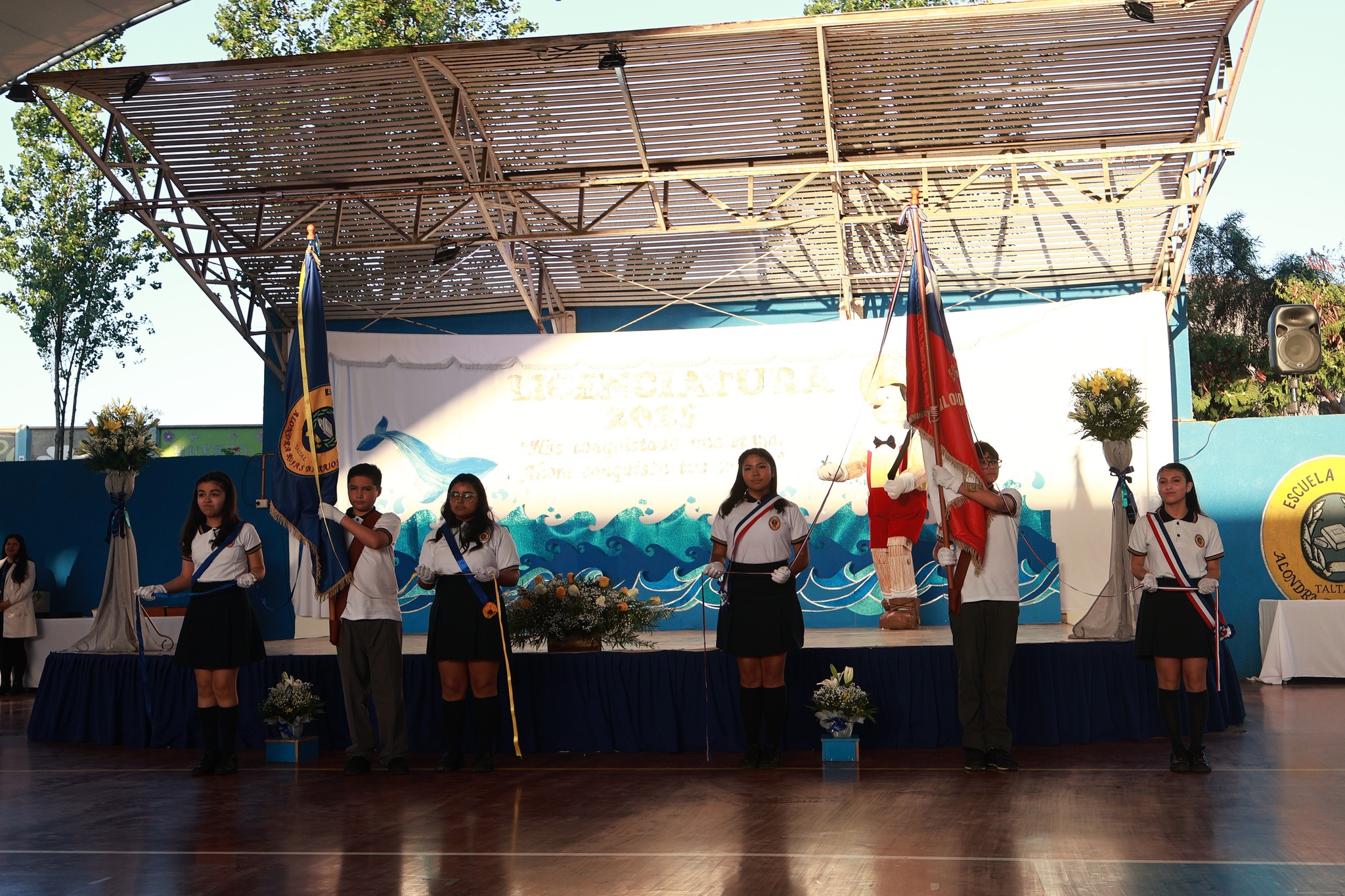 Momento simbólico del traspaso de estandartes institucionales entre los alumnos de la promoción 2025.