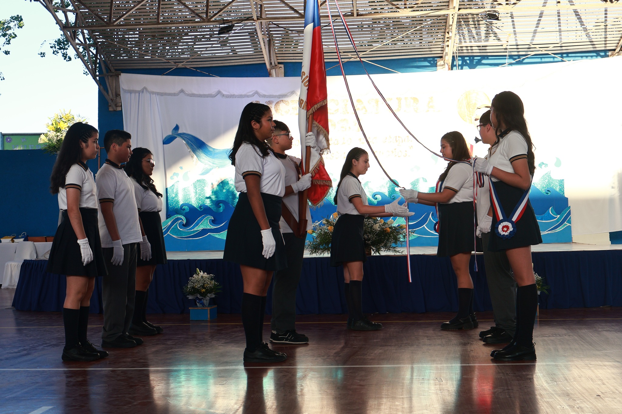 Formación de estudiantes con bandera chilena y estandarte institucional<br />

