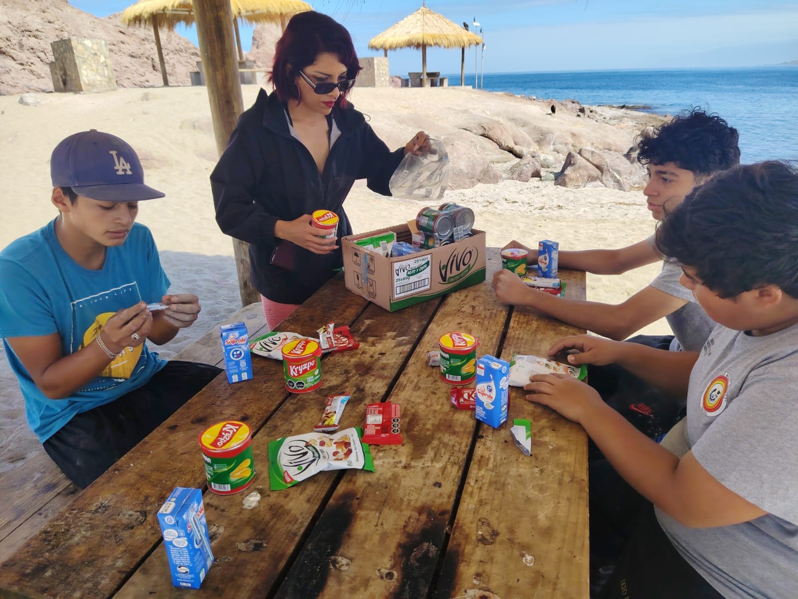 El grupo de estudiantes compartiendo una colación durante la jornada de intervención en el borde costero.