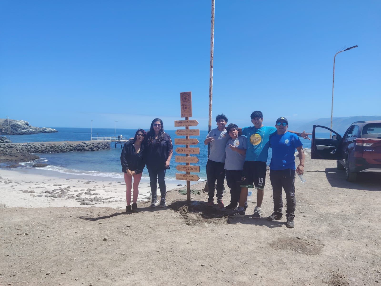Estudiantes y equipo de apoyo trabajando en la fijación de señalética financiada por Fundación Pan American Silver.