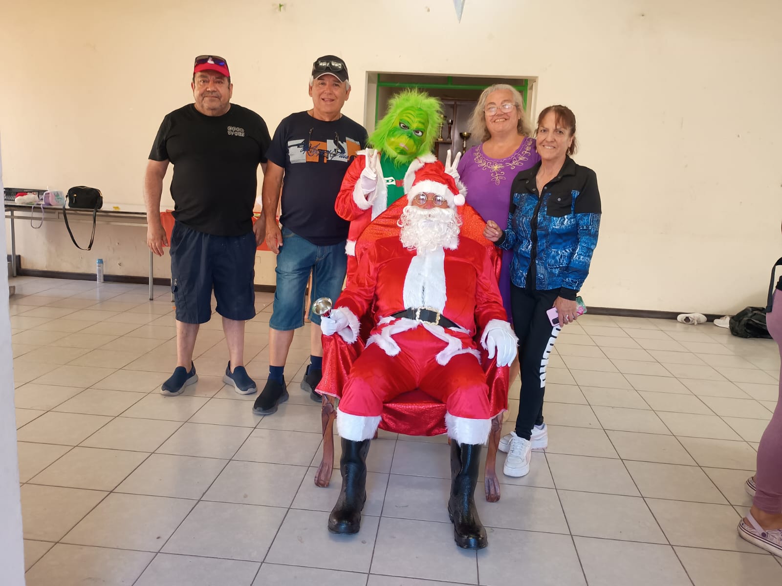 Vecinas y vecinos posan junto a Papá Noel en actividad navideña del barrio Eduardo Vigil en Taltal