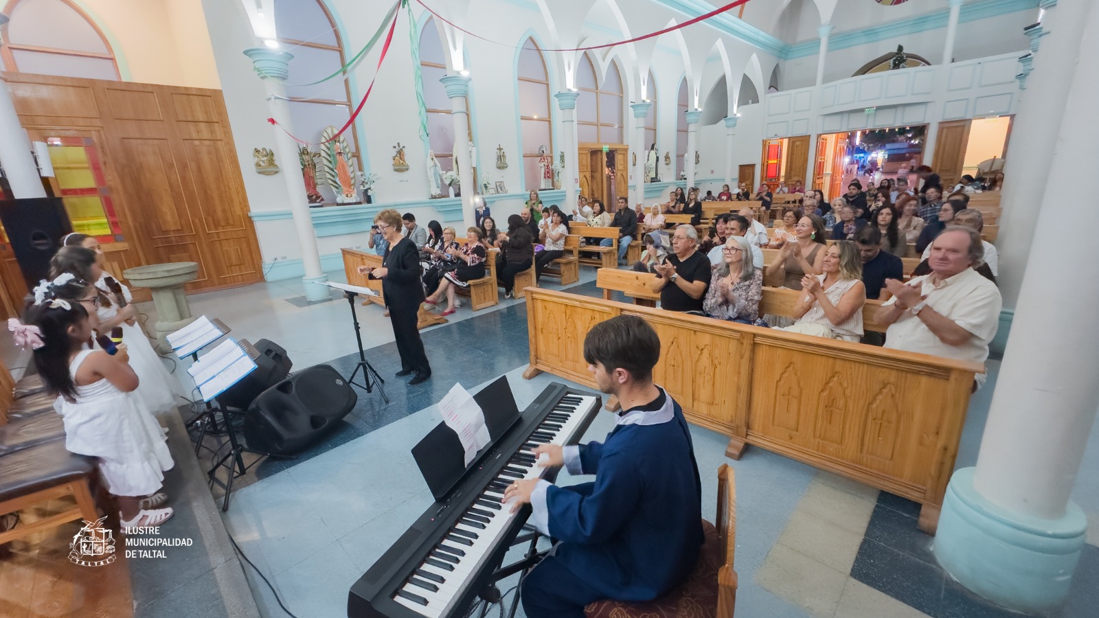 Vecinos y vecinas de Taltal llenando las bancas de la Iglesia San Francisco Javier durante el tradicional encuentro musical.