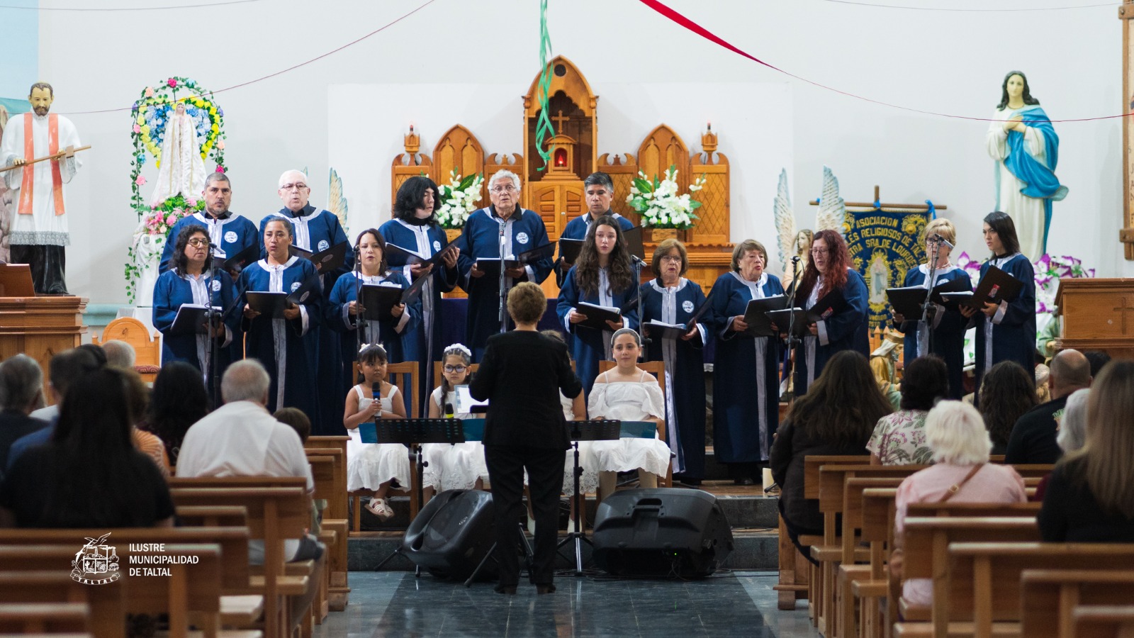 El Coro de Cámara de Taltal interpretando villancicos y piezas navideñas frente al altar de la iglesia.