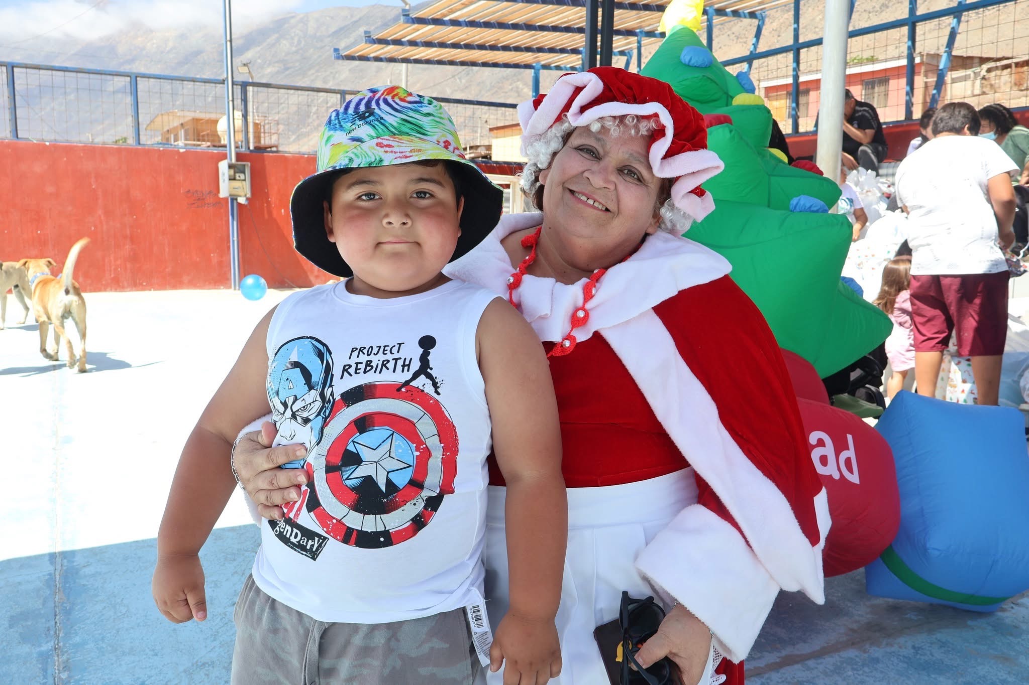 Niño y Señora Closs en fotografía de recuerdo durante jornada navideña en Paposo.