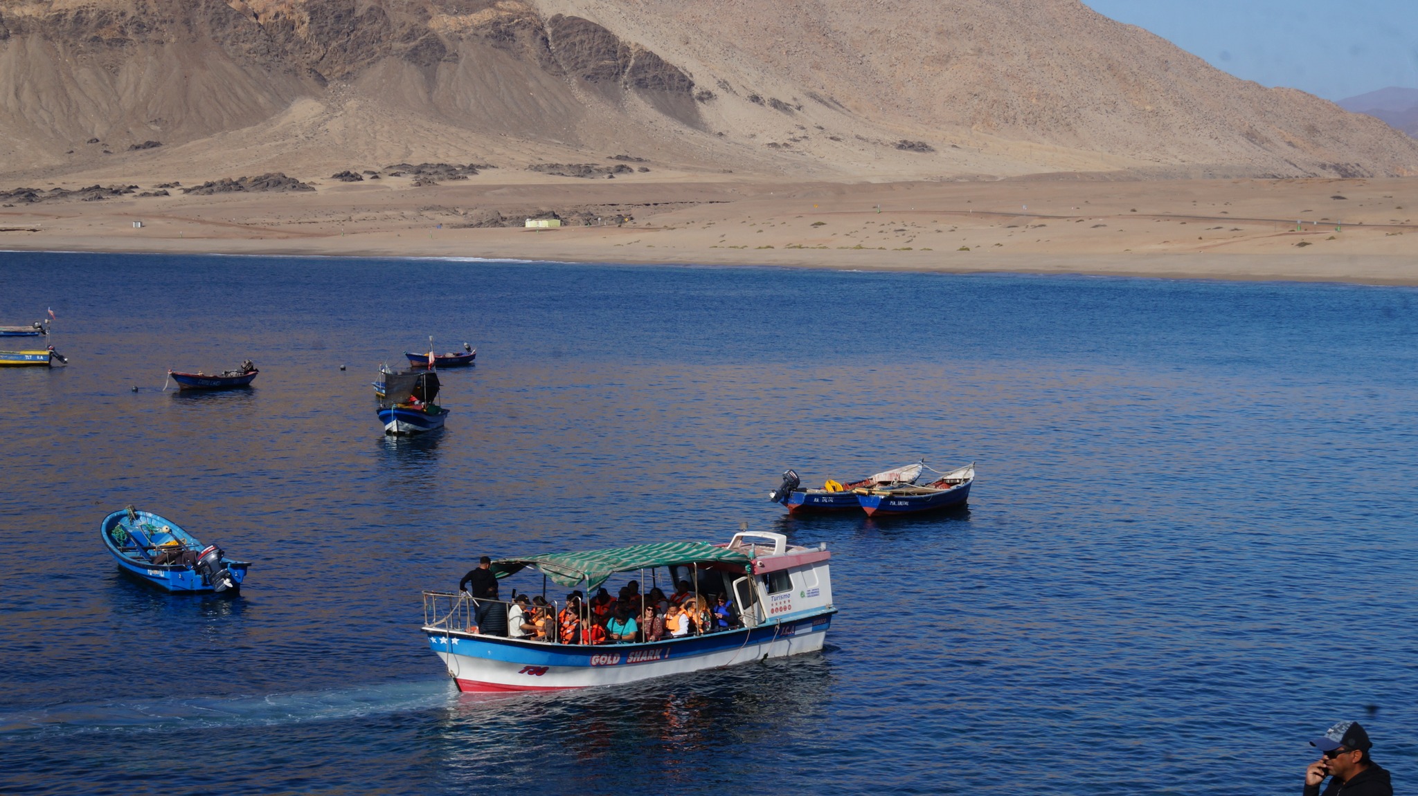 Embarcación con turistas navegando en las aguas turquesas de Caleta Cifuncho durante la temporada estival en Taltal.