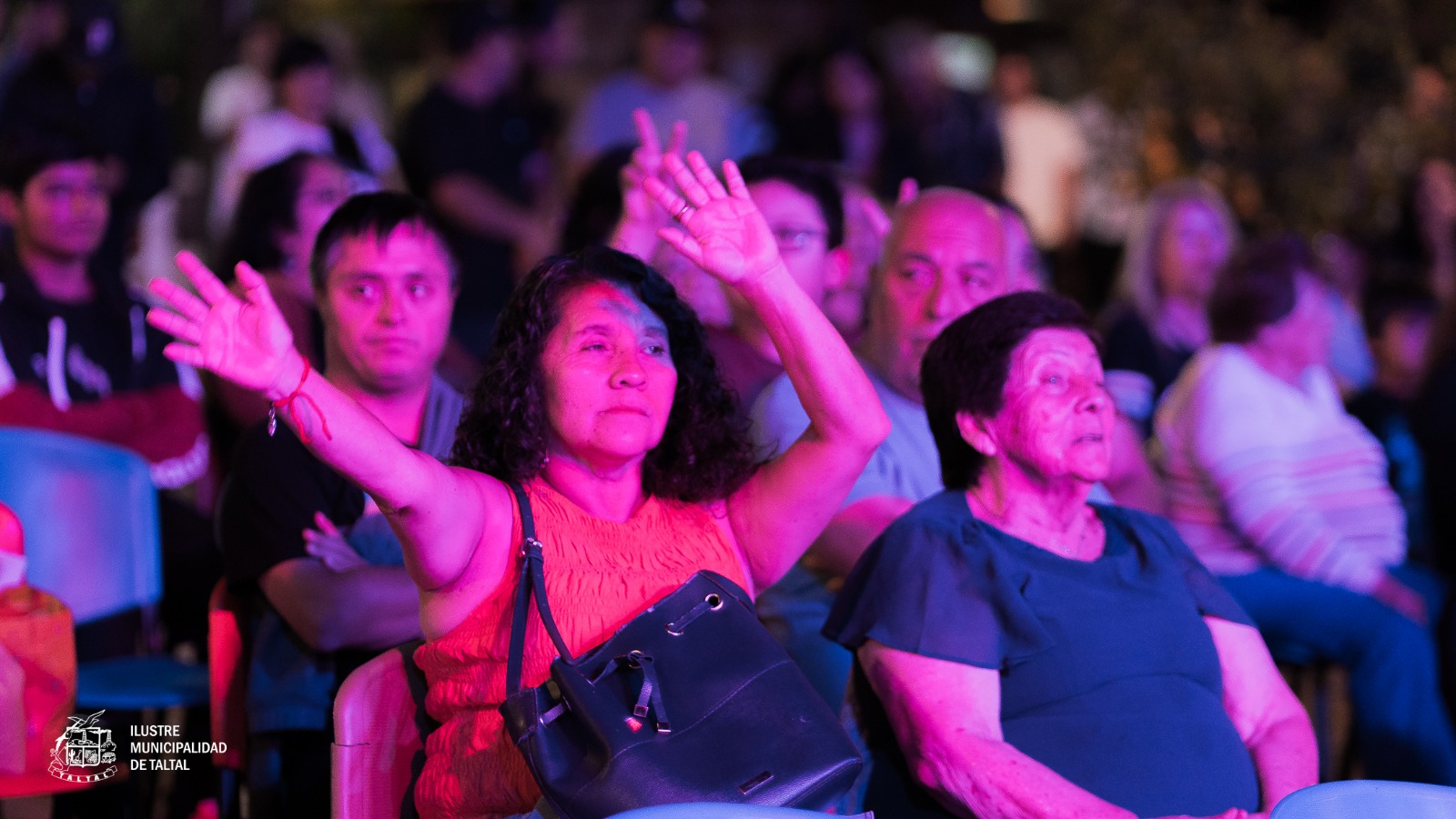 Público asistente participando con entusiasmo desde las sillas en la Plaza de Armas.