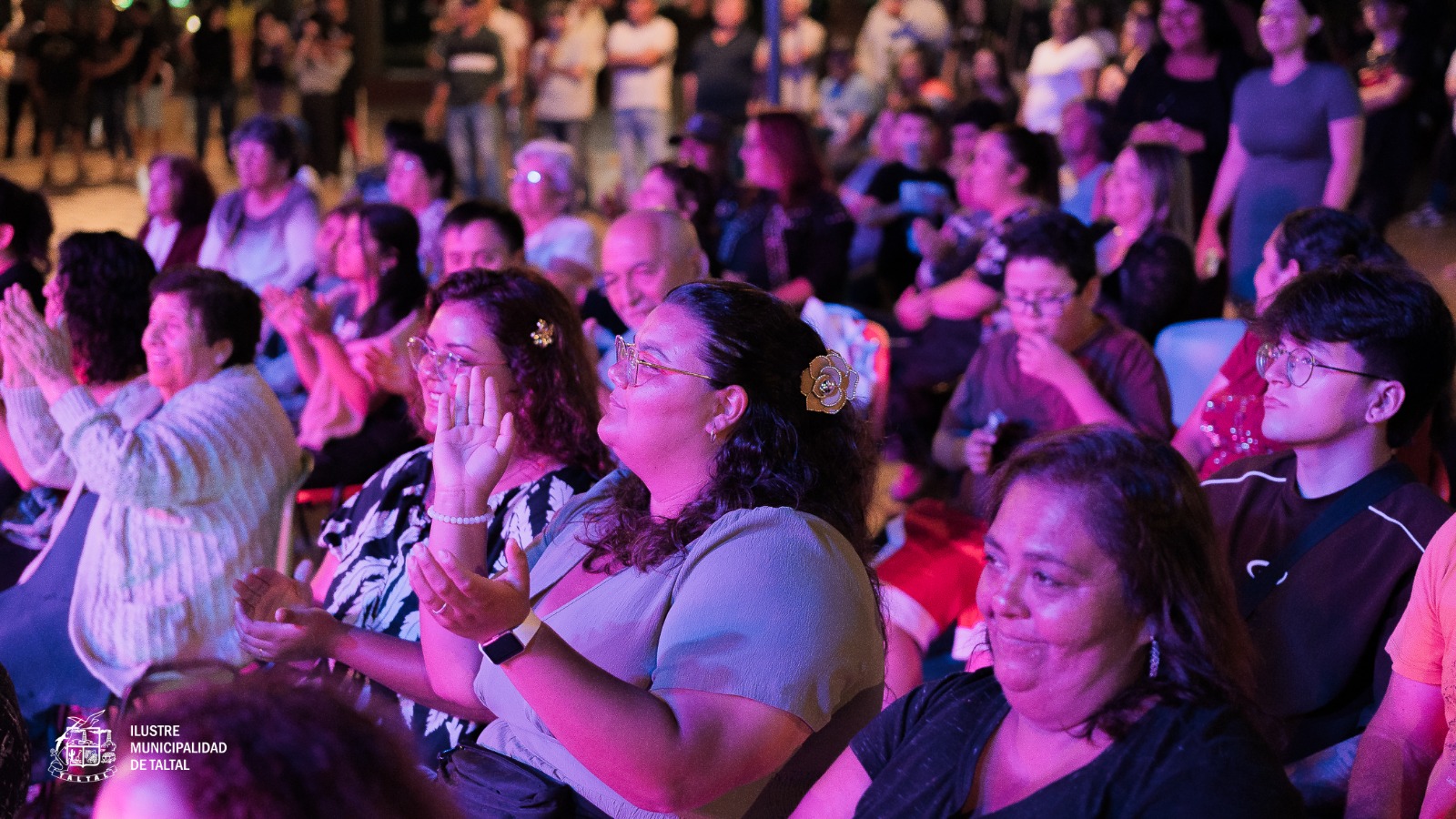 Cientos de personas disfrutando y aplaudiendo en la Plaza de Armas durante la noche de verano.