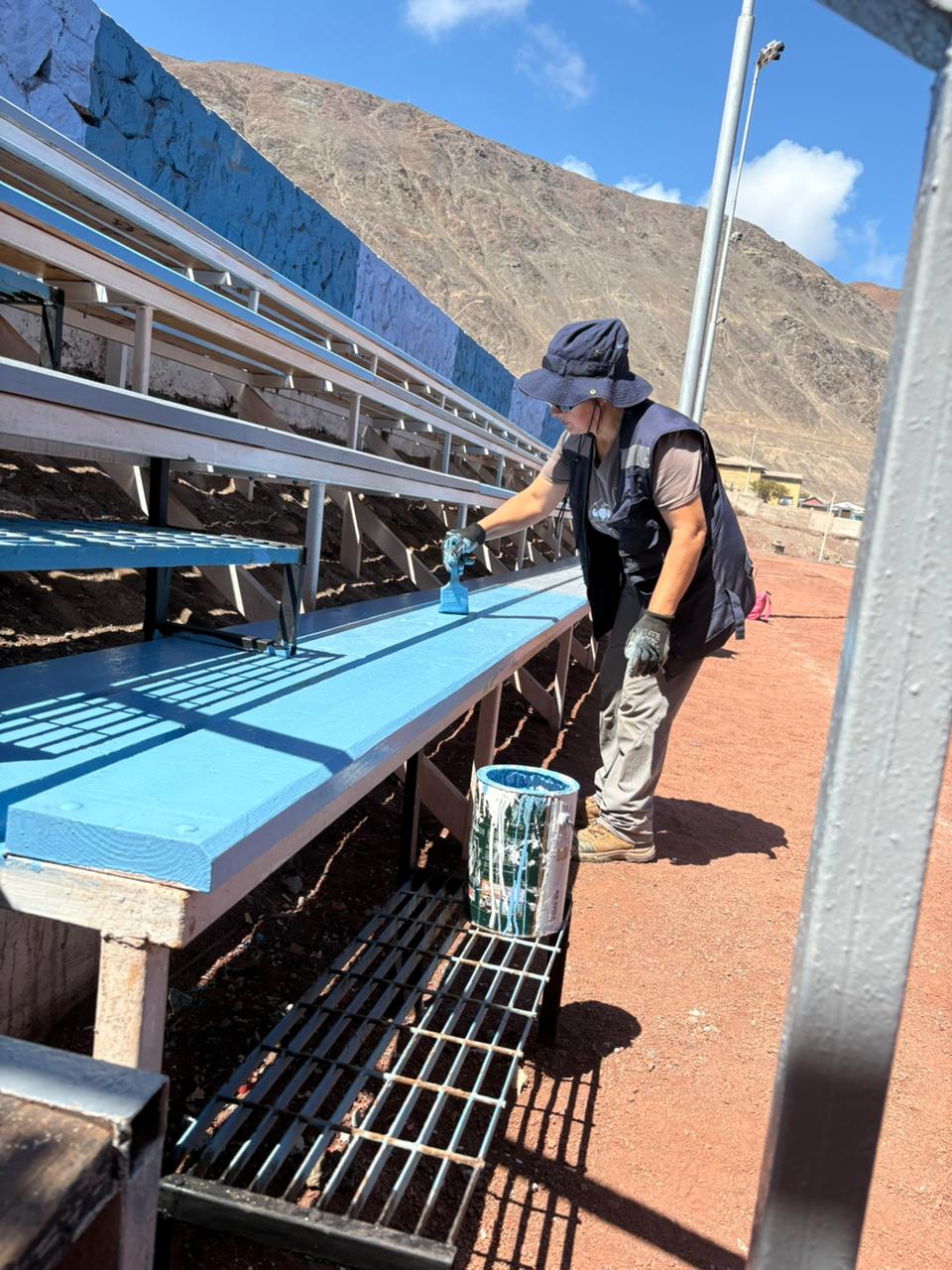 Detalle del proceso de pintado manual para asegurar la durabilidad de las instalaciones deportivas.
