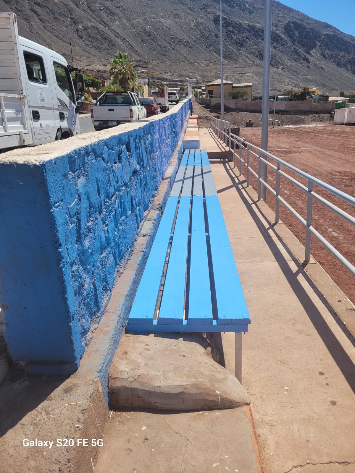 Fila de graderías terminadas con colores azulados, listas para recibir al público del campeonato de verano.
