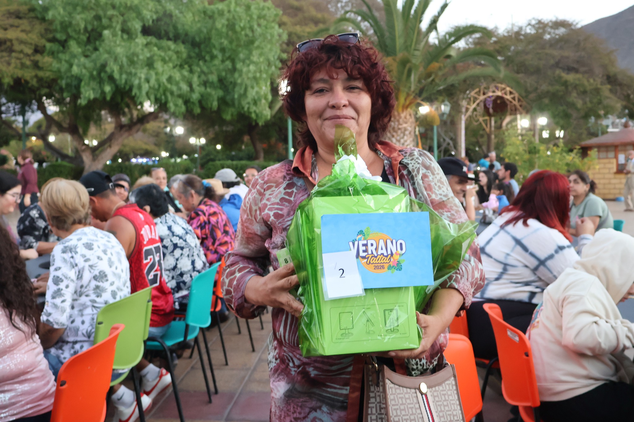 Vecina de Taltal recibe un premio de la organización durante la jornada de recreación familiar.