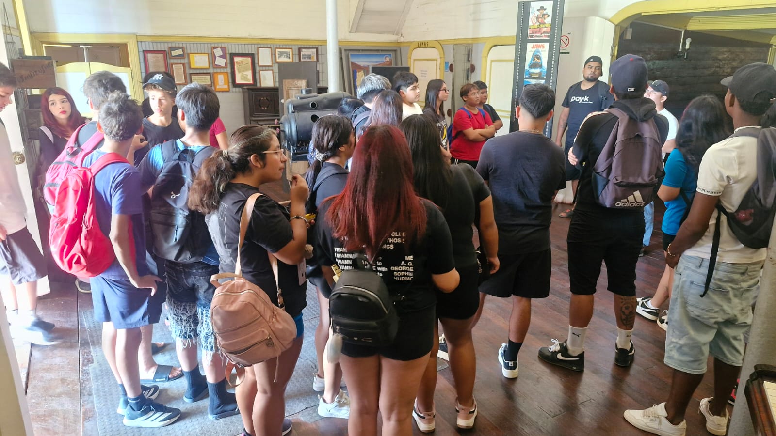Delegación de estudiantes escuchando atentamente durante un recorrido patrimonial.