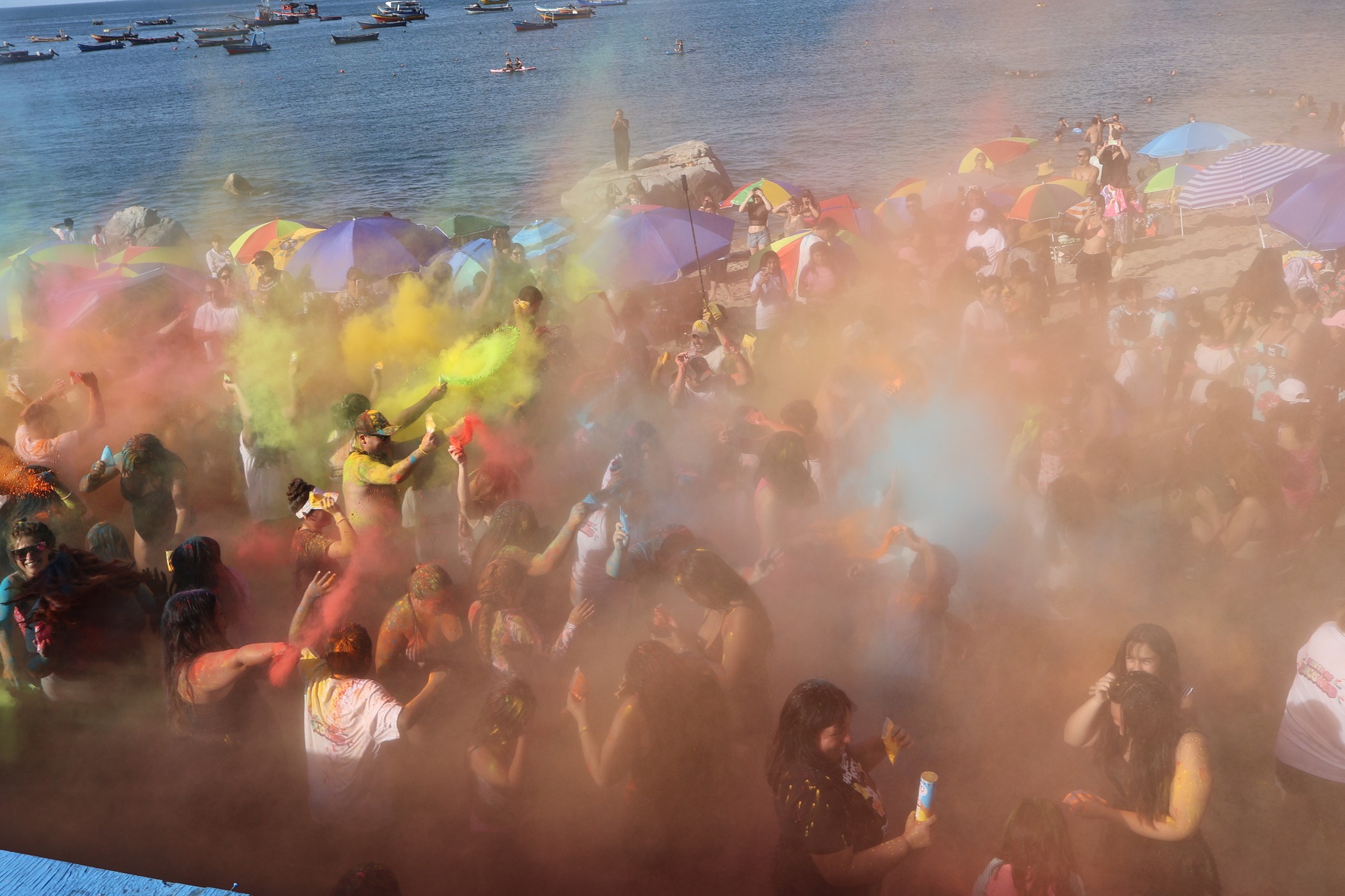 Momento de máxima energía con el lanzamiento de polvos de colores frente al mar.