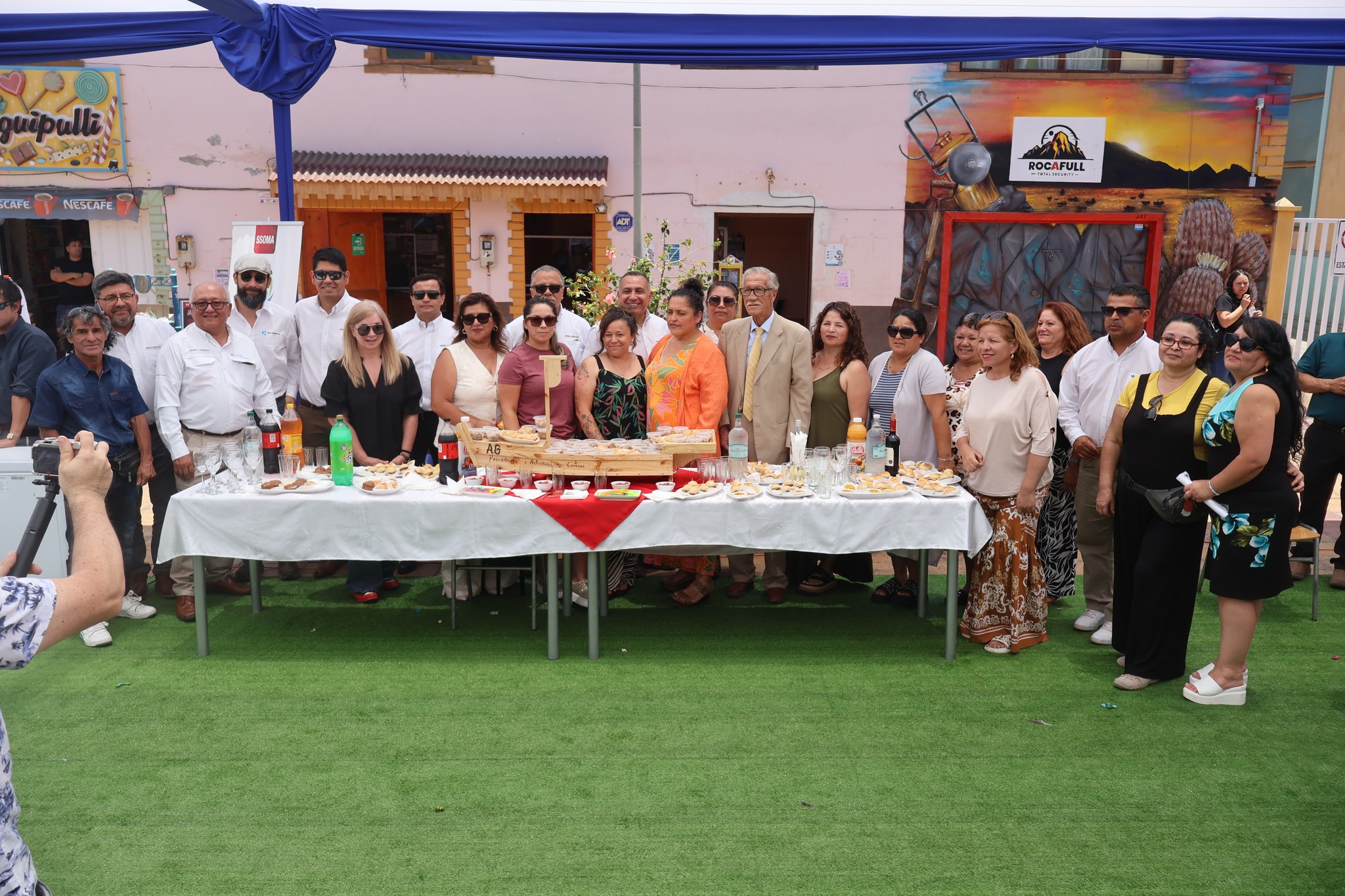 Foto grupal de autoridades, equipos y vecinos en el cierre del Día INTEGRAR en Taltal, con mesa de camaradería.