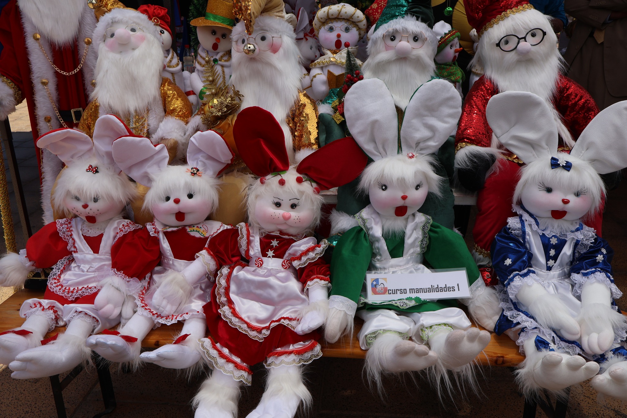 Muñecos y artesanías exhibidas en la exposición del curso municipal de manualidades durante el Día INTEGRAR en Taltal.