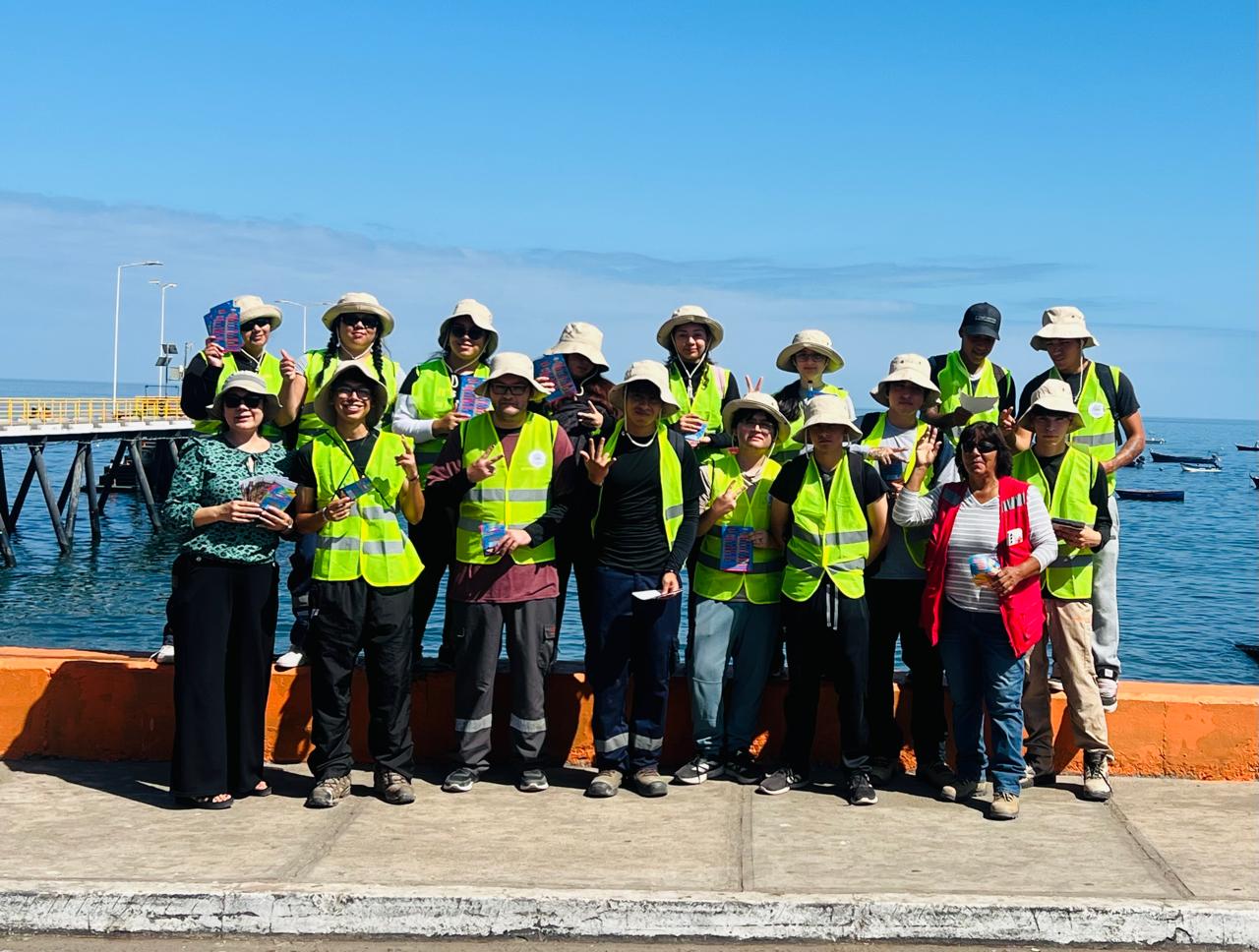 Cientos de personas reunidas en Plaza de Armas para el bingo veraniego frente a la iglesia al atardecer.