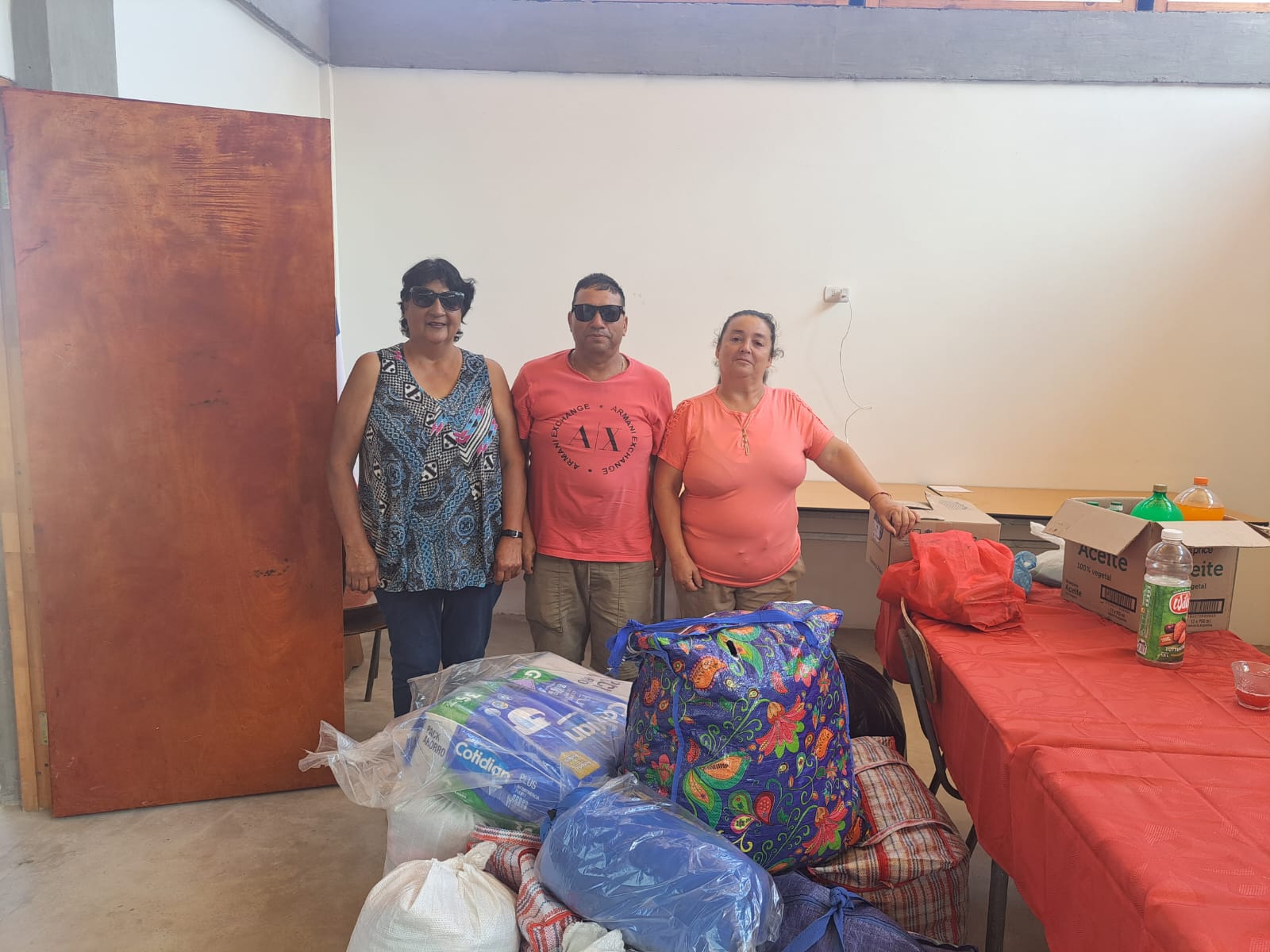 Dirigentes y vecinos de Paposo posan junto a donaciones reunidas para apoyar a familias damnificadas por los incendios en el sur de Chile, en centro de acopio de Taltal.