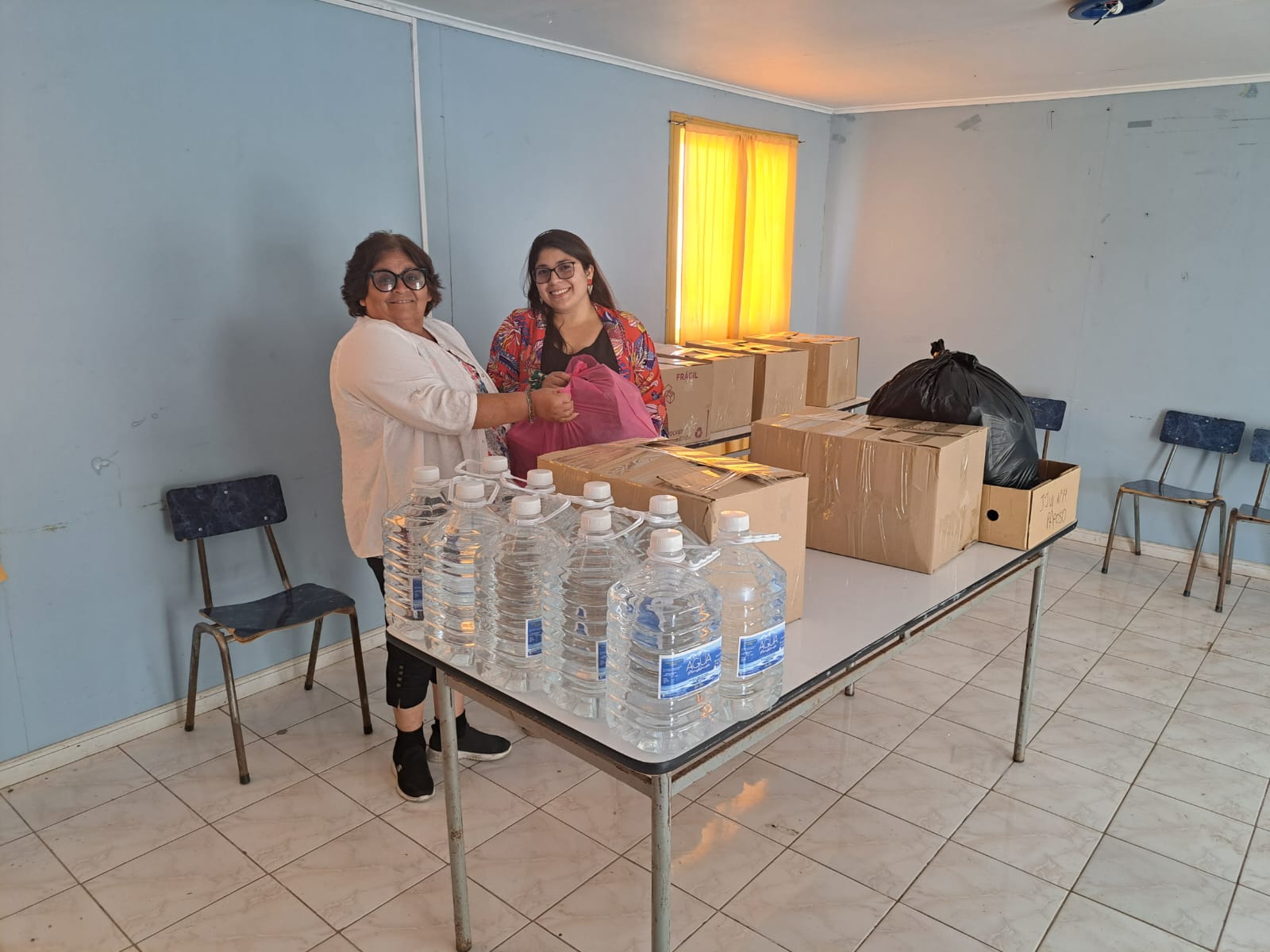 Voluntarias de Paposo organizan agua y cajas con ayuda solidaria para familias afectadas por incendios forestales en el sur de Chile, en centro de acopio de Taltal.