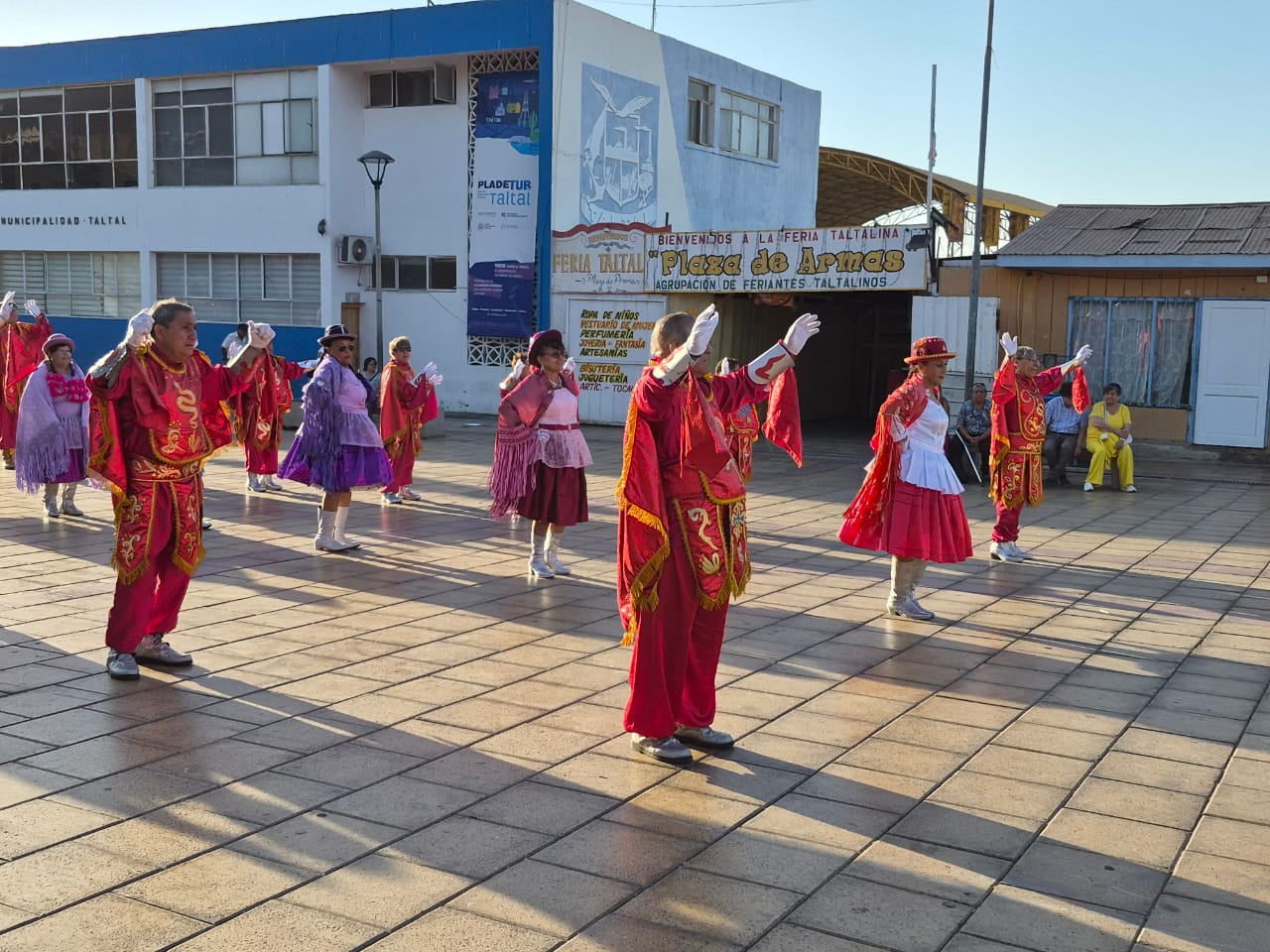 Integrantes de agrupación de adultos mayores realizan bailes típicos del norte en la Plaza de Armas de Taltal, con trajes tradicionales y público alrededor.