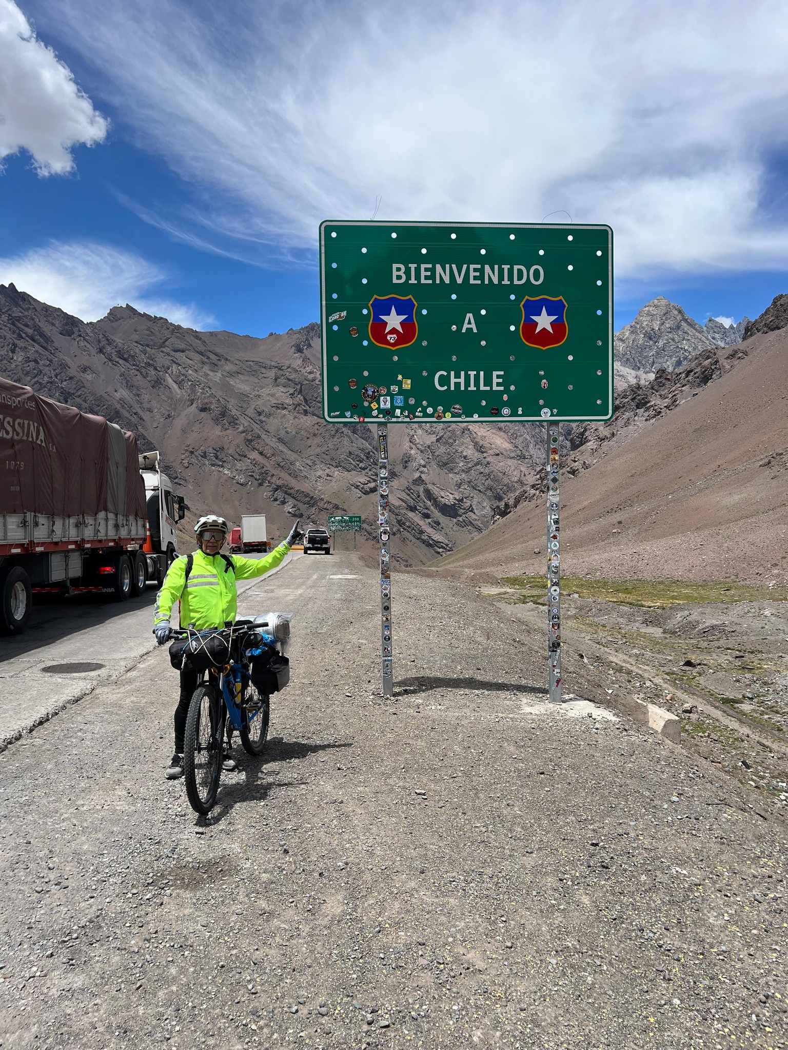 Pedro Lemus junto al cartel “Bienvenido a Chile”, registrando el cruce de frontera durante su travesía en bicicleta desde Mendoza.