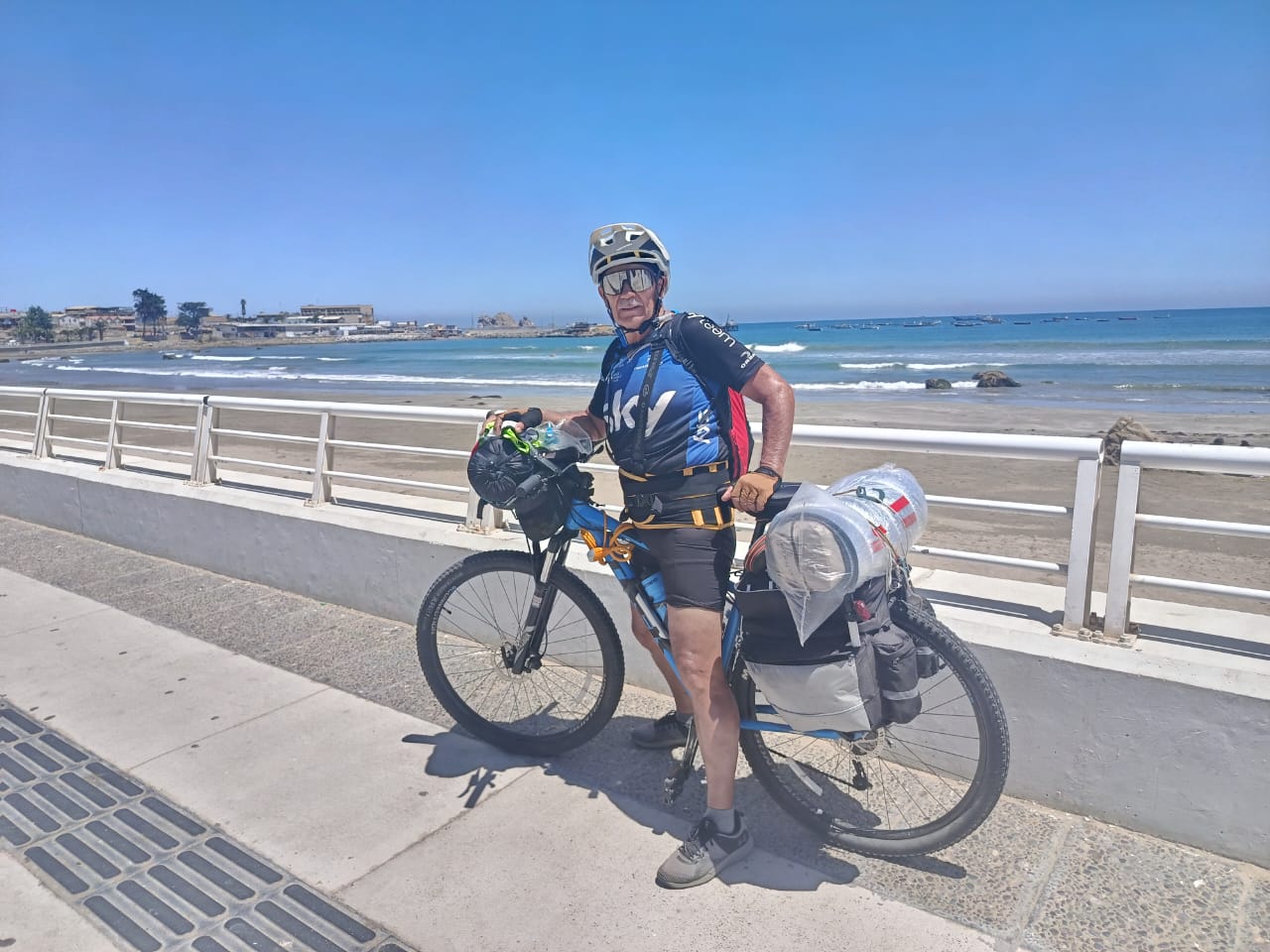 Pedro Lemus con su bicicleta y equipaje frente al mar, durante el tramo costero de su travesía rumbo a Taltal.