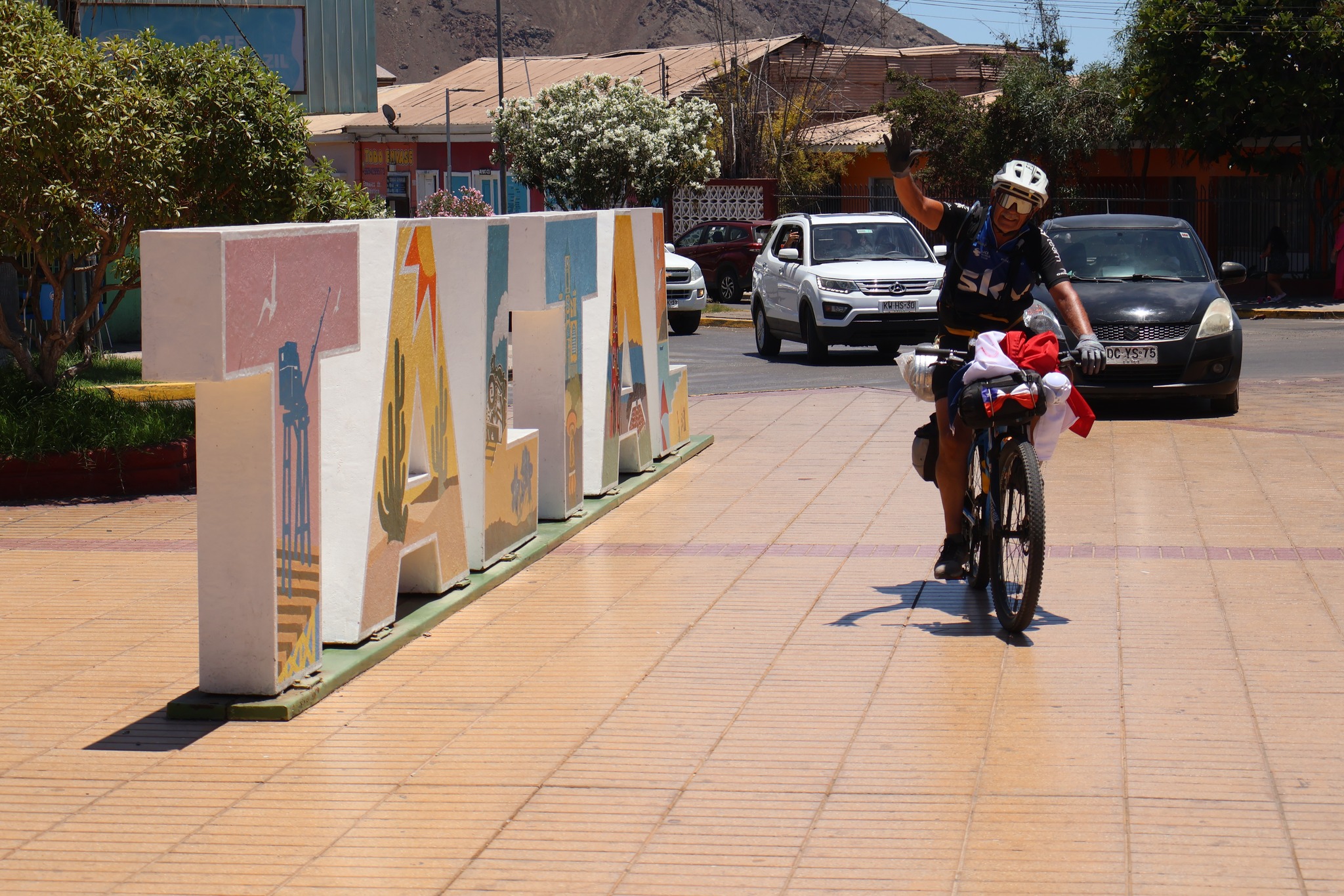 Pedro Lemus ingresa en bicicleta y saluda junto al letrero “TALTAL”, marcando su llegada tras la travesía desde Mendoza.