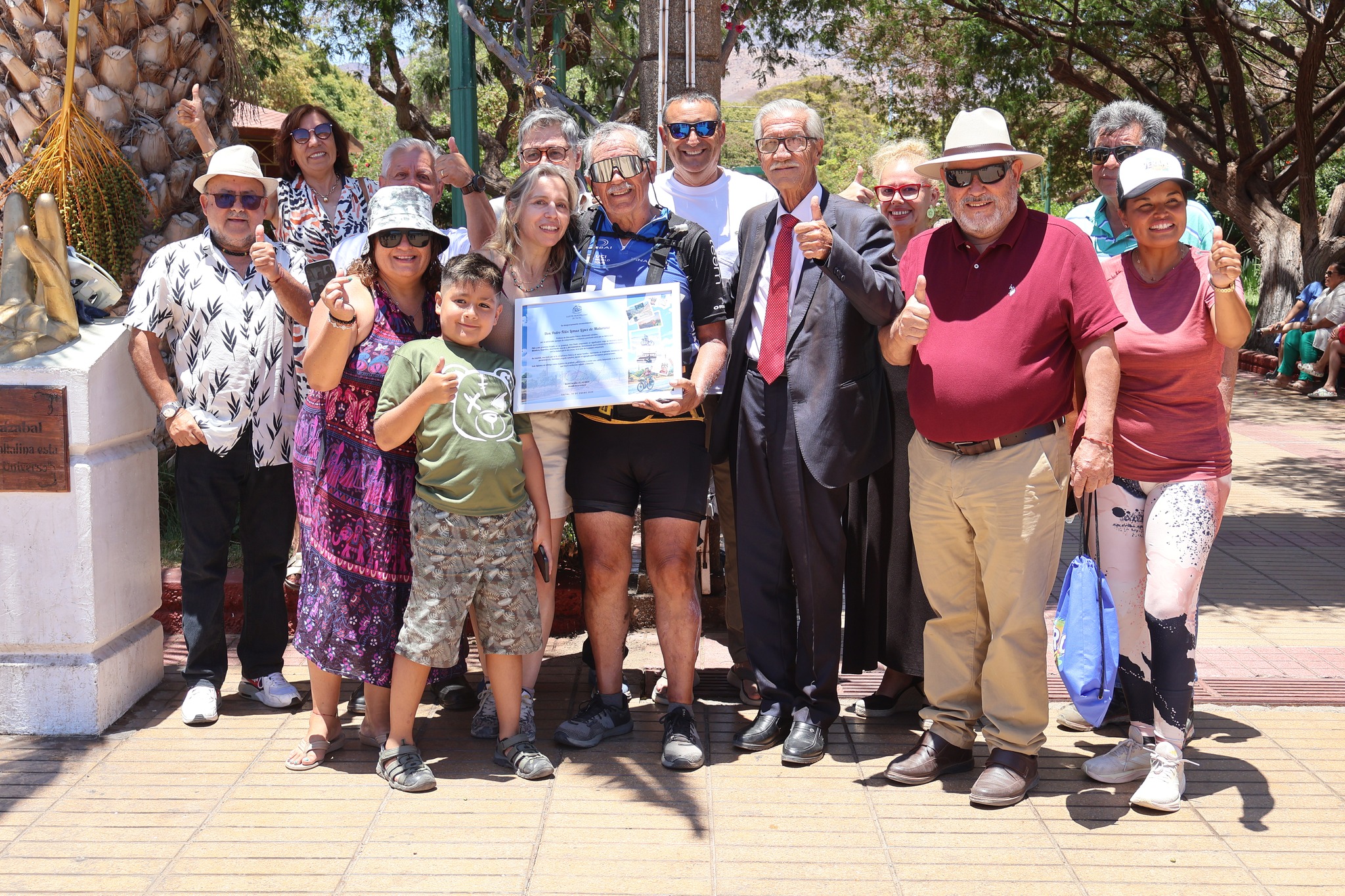 Grupo de vecinos, familiares y autoridades posa junto a Pedro Lemus en la plaza de Taltal, durante el reconocimiento comunitario por su travesía en bicicleta desde Mendoza.