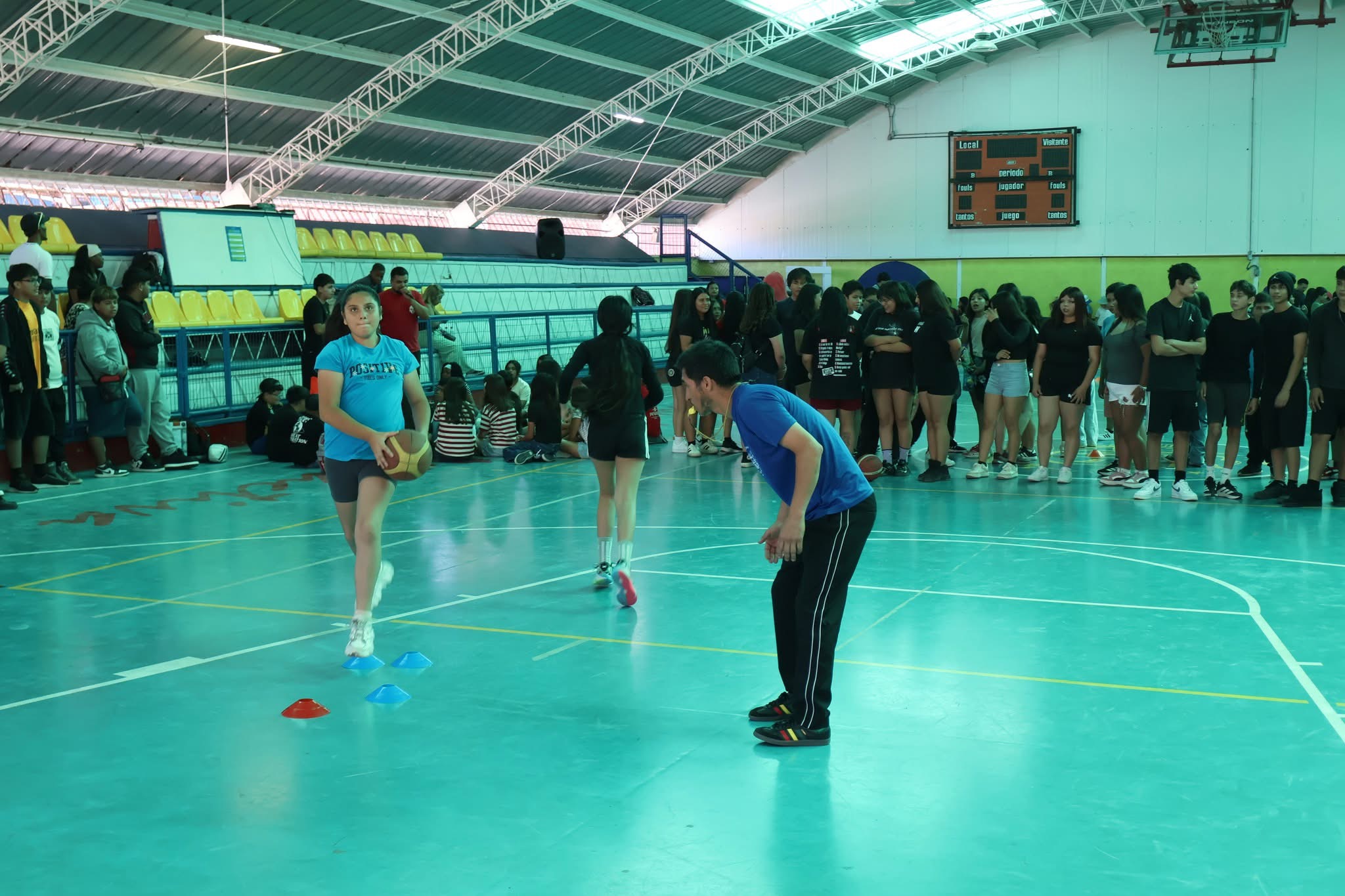 Niña practicando ejercicios de coordinación con conos durante los talleres deportivos de verano.