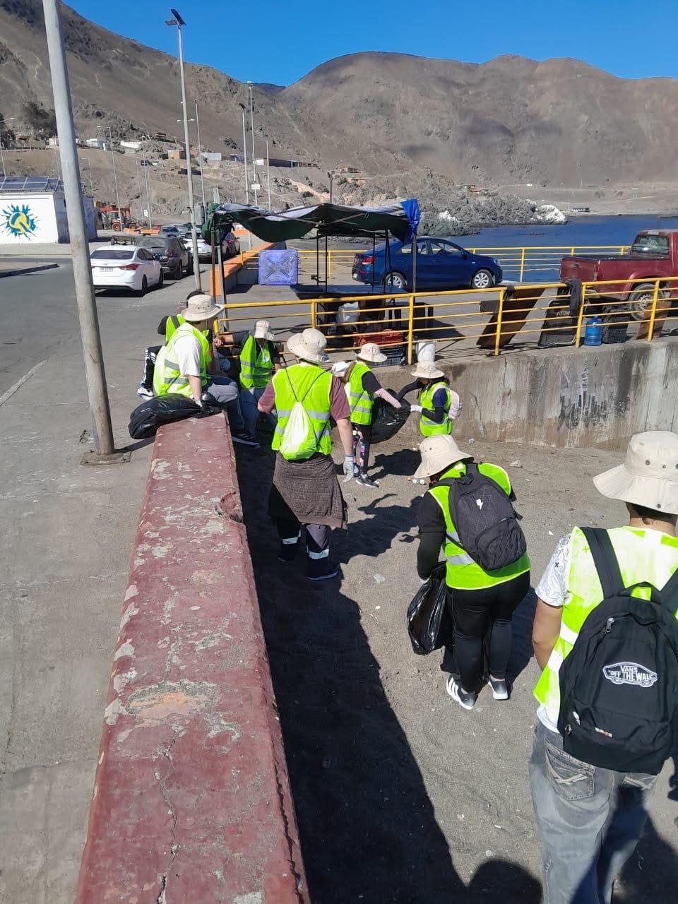 Integrantes del programa municipal recolectando residuos en sacos negros en el sector de La Puntilla.