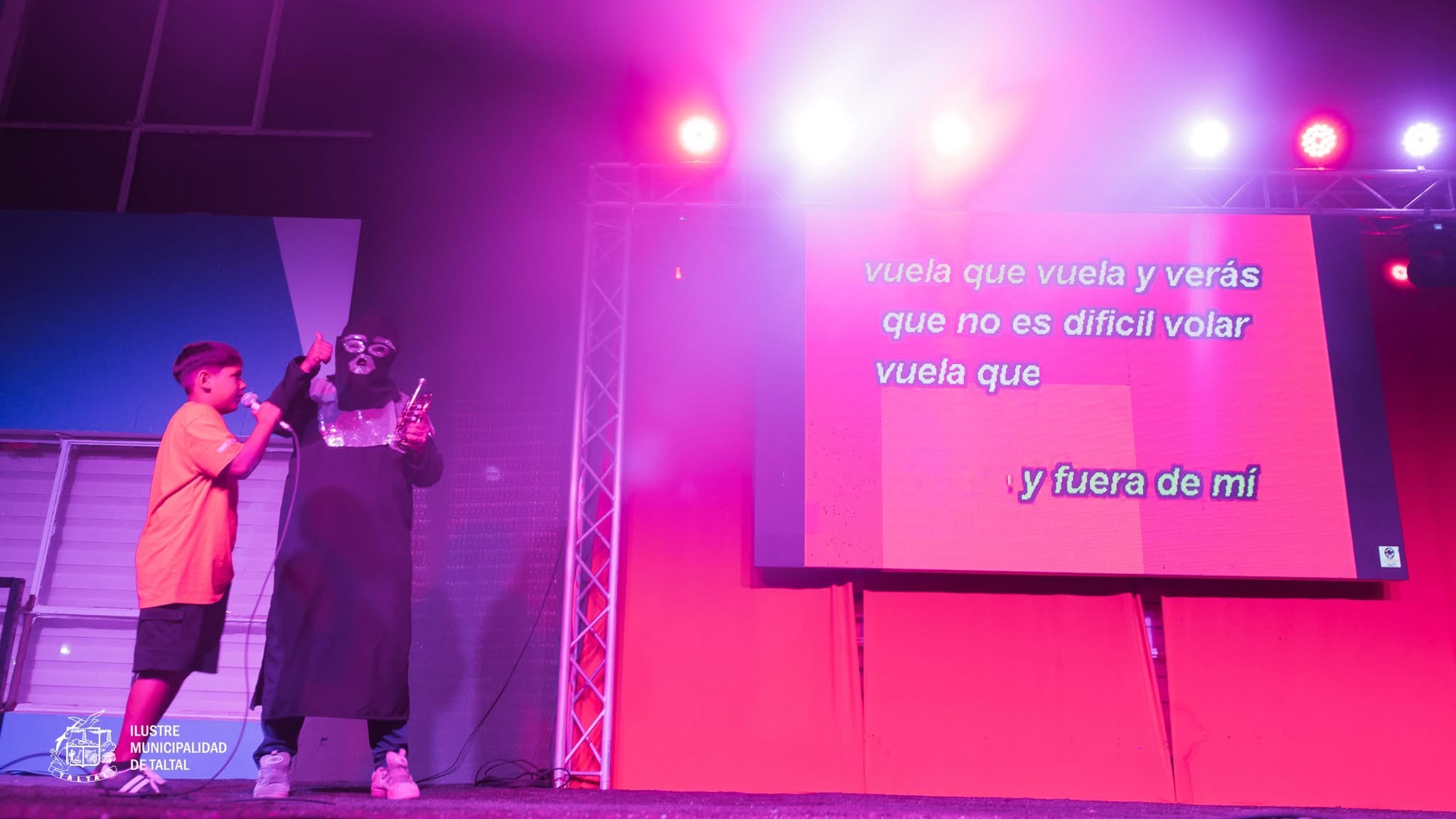 Un niño de la comuna cantando junto al Chacal de la Trompeta en la Plaza de Armas.