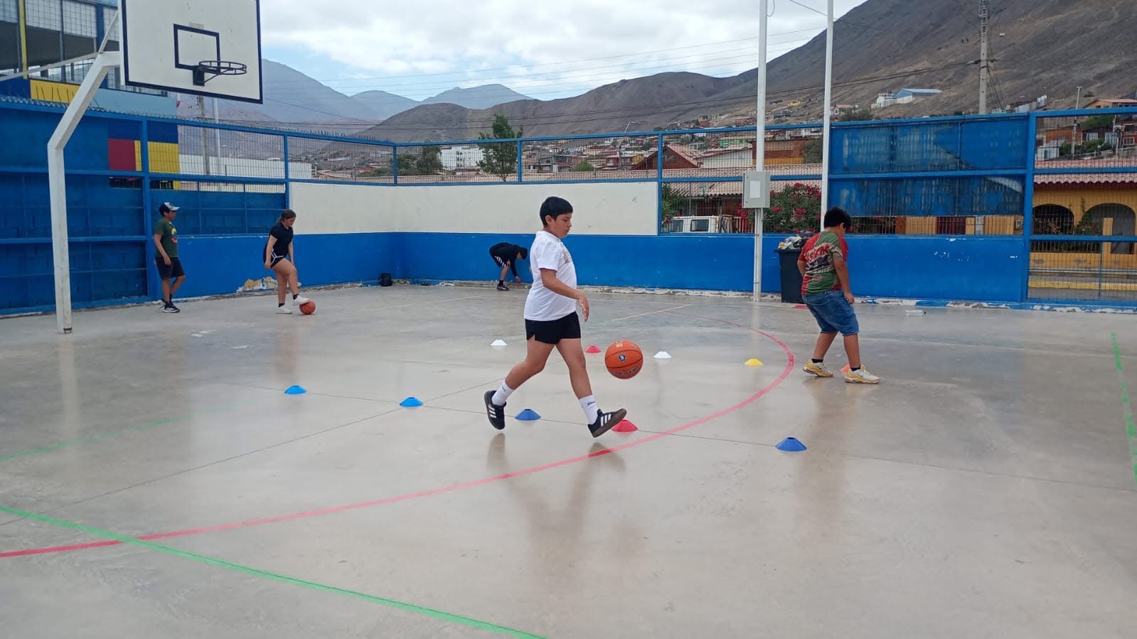 Alumno realizando ejercicios de coordinación con balón de básquetbol.