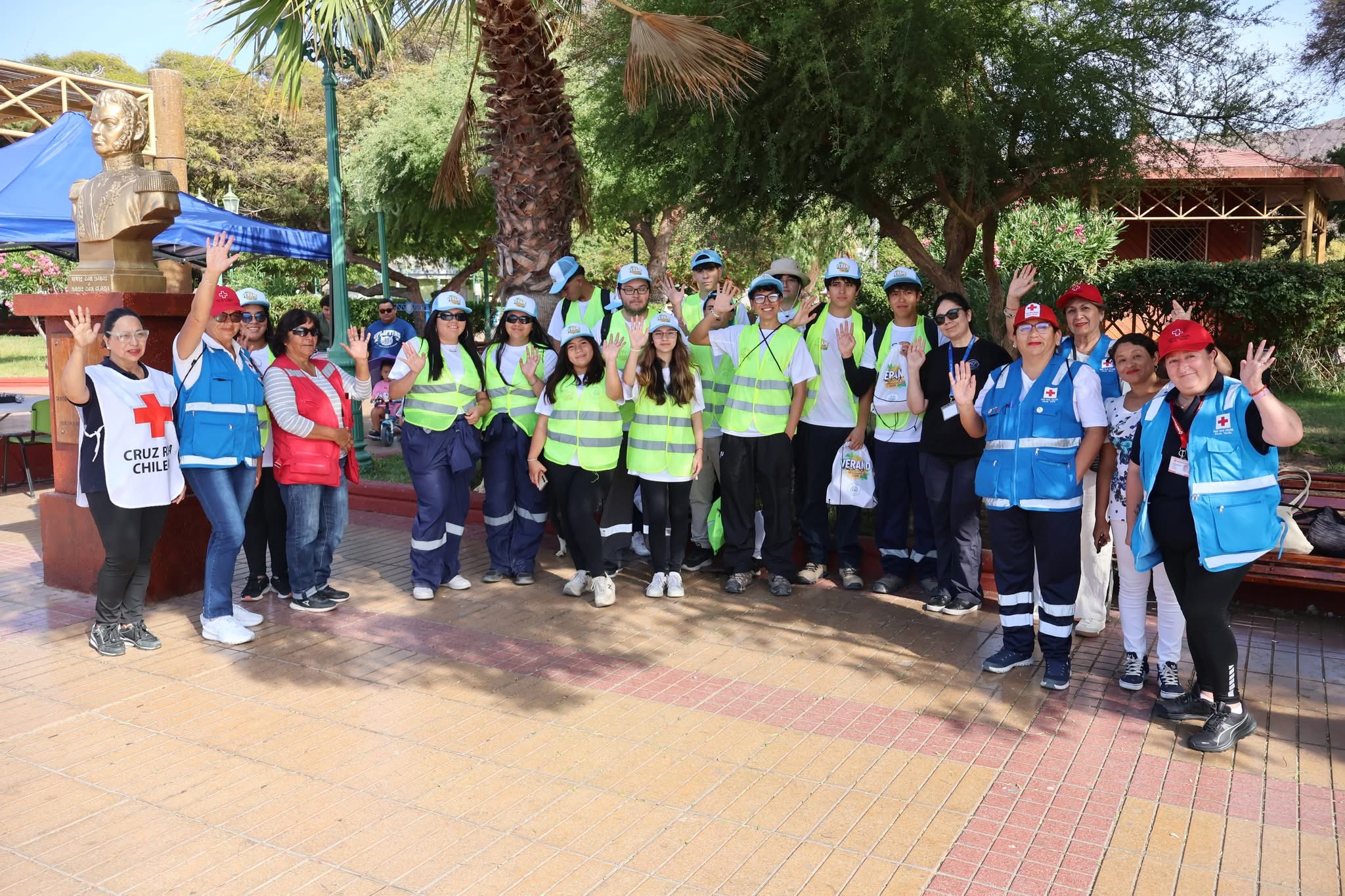 Jóvenes del Team de Verano y voluntarias de Cruz Roja Chilena saludando antes de iniciar el puerta a puerta.