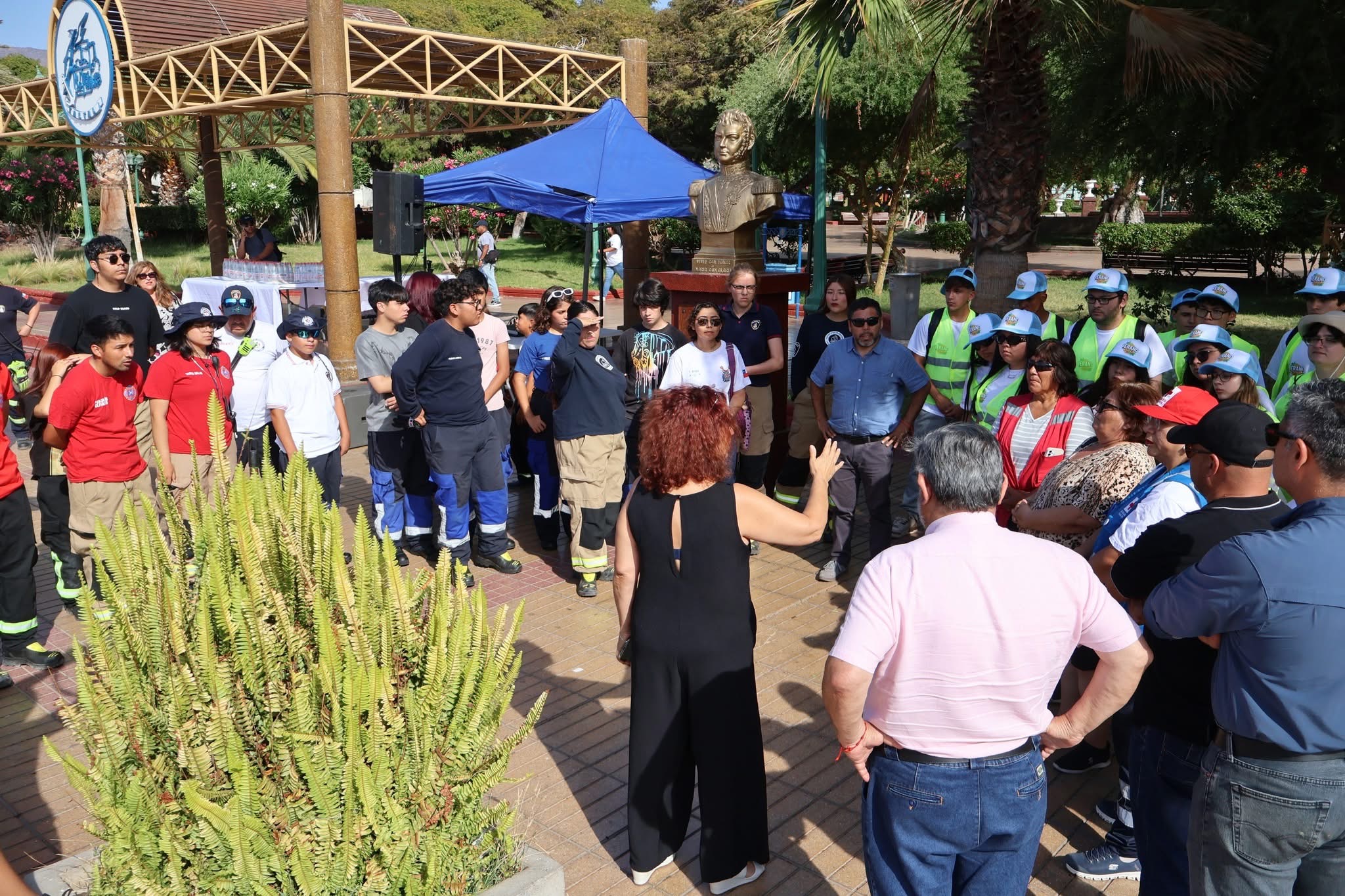 Autoridades locales y representantes de instituciones coordinando las rutas de recolección en la plaza.