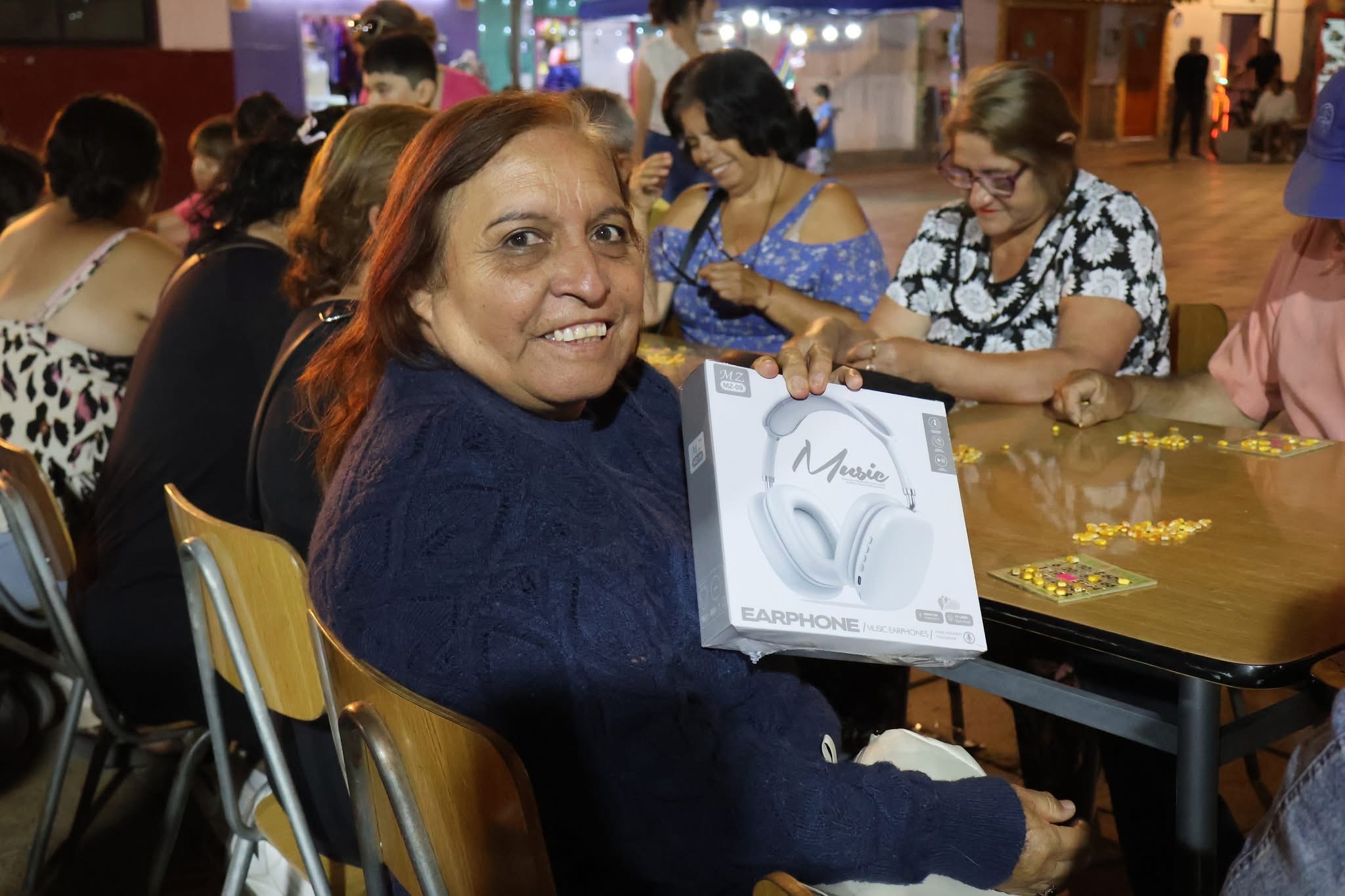 Vecina de Taltal feliz tras ganar unos audífonos en la segunda jornada del bingo municipal.