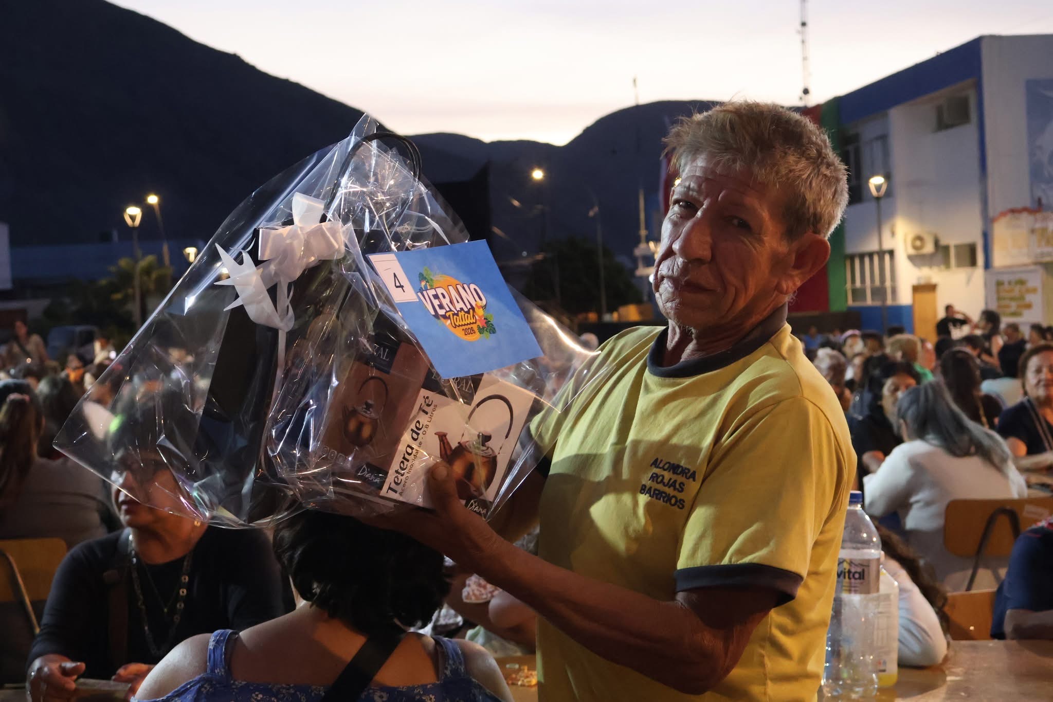 Adulto mayor de Taltal feliz con su premio de tetera eléctrica en la Plaza de Armas.