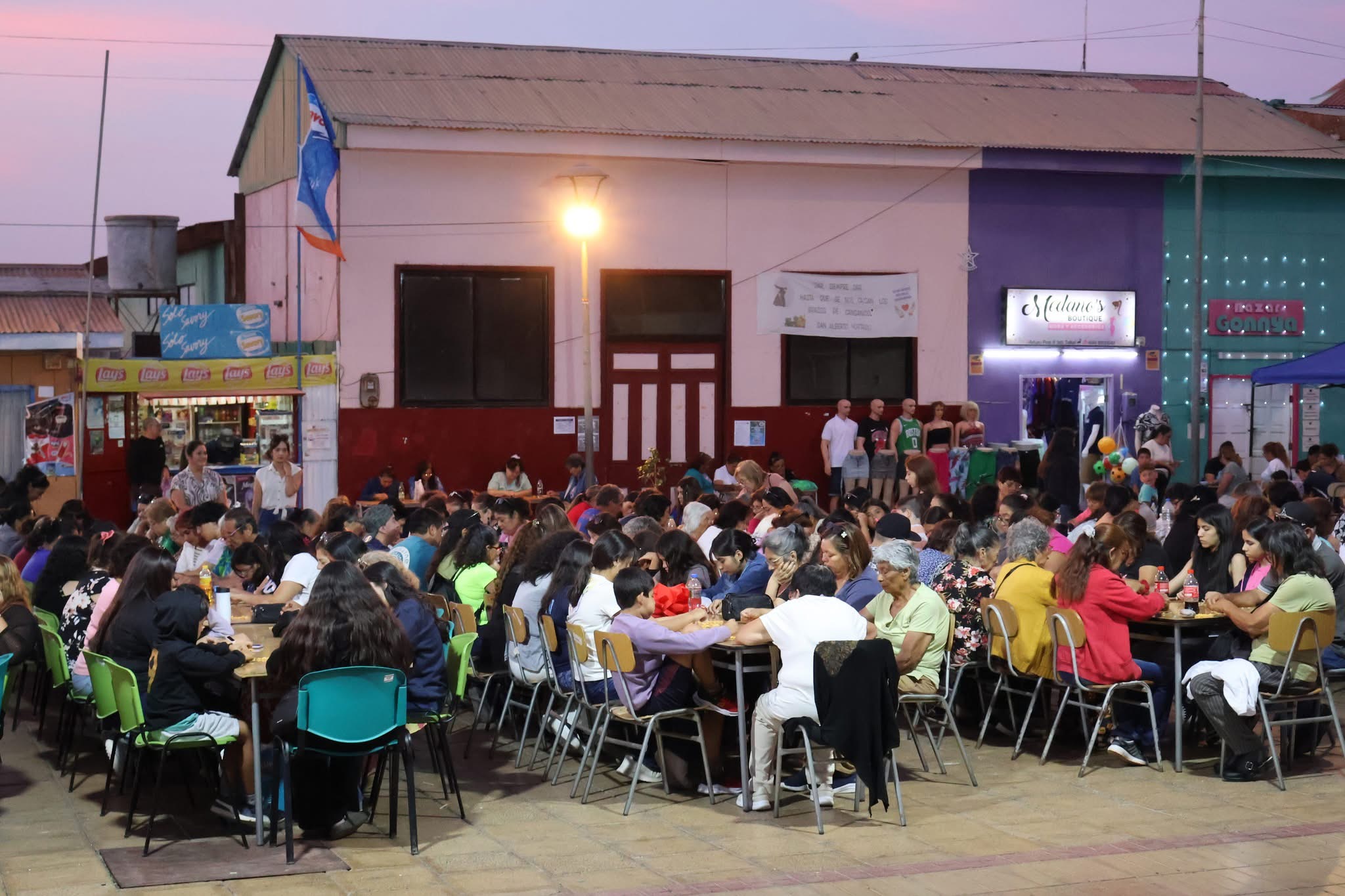 Vista detallada de las familias taltalinas participando concentradas en sus cartones de bingo.