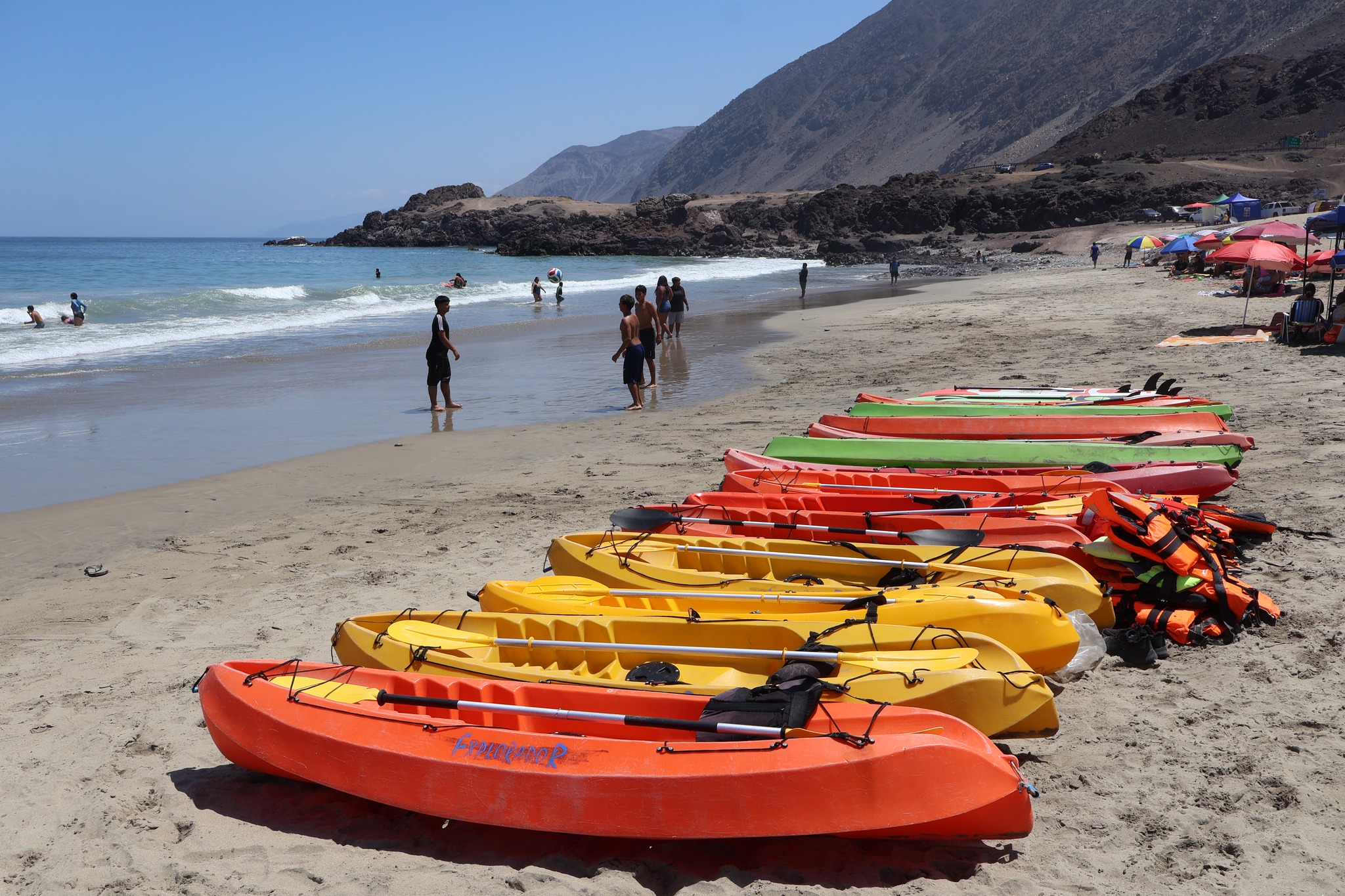 Kayaks dispuestos en la arena para actividades acuáticas en Playa Tierra del Moro durante jornada veraniega.