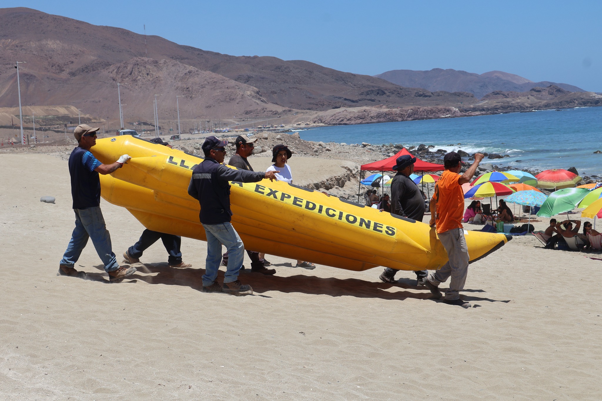 Equipo traslada banano acuático para actividad recreativa en Playa Tierra del Moro durante evento de verano.