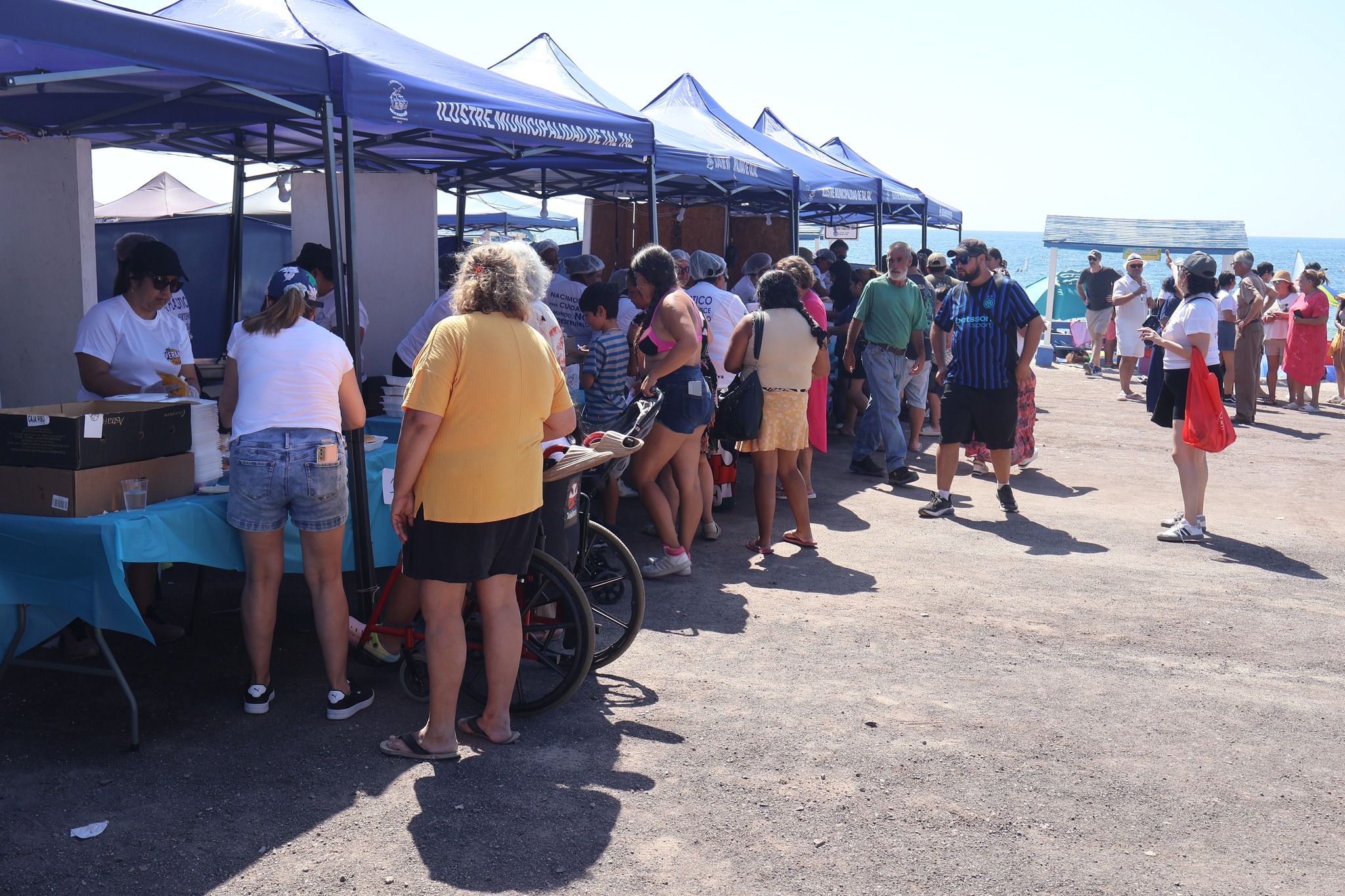 Atención a público en carpas durante la actividad de verano en Playa Tierra del Moro, Taltal.