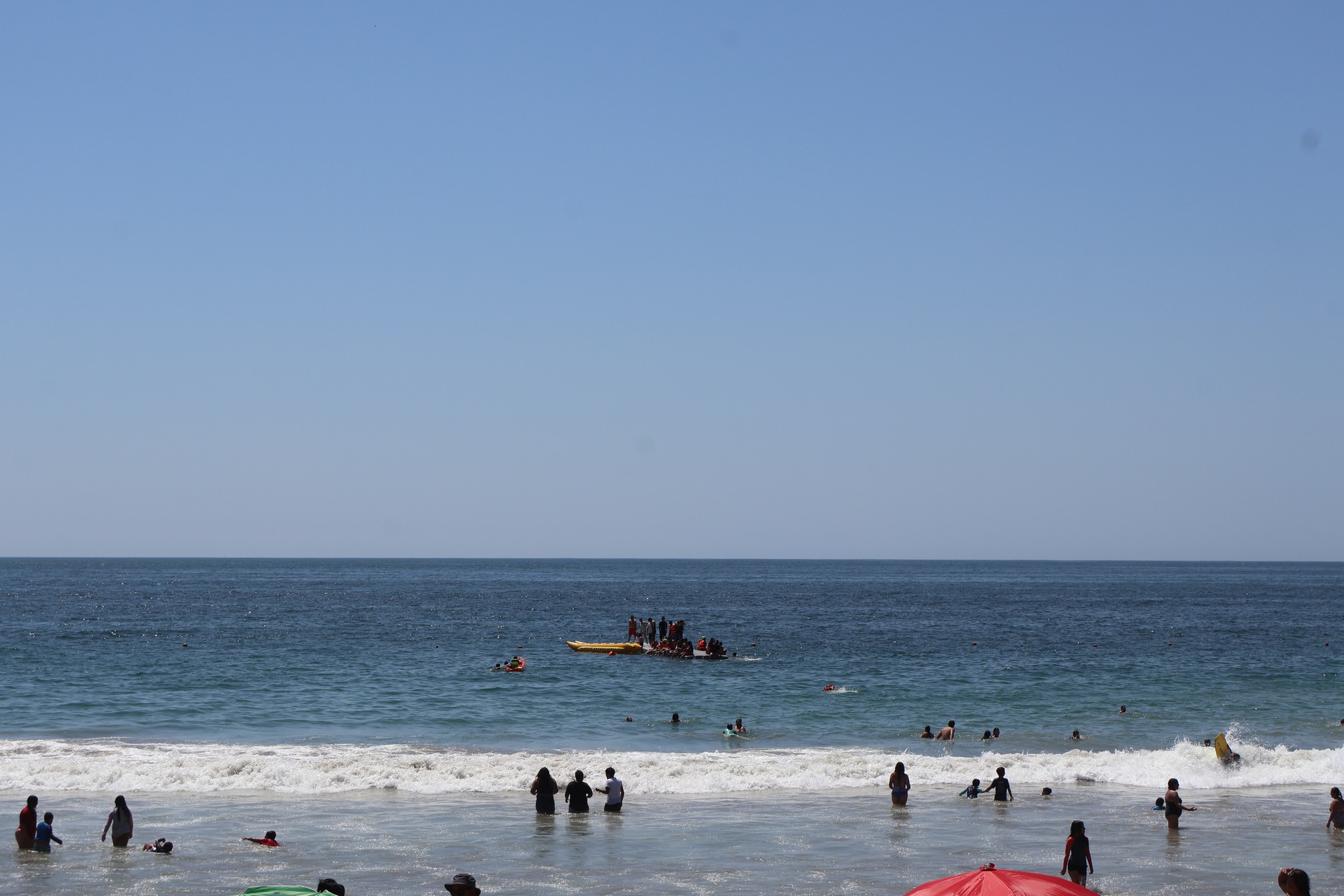Vista del mar con actividades acuáticas y público en Playa Tierra del Moro durante jornada veraniega en Taltal.