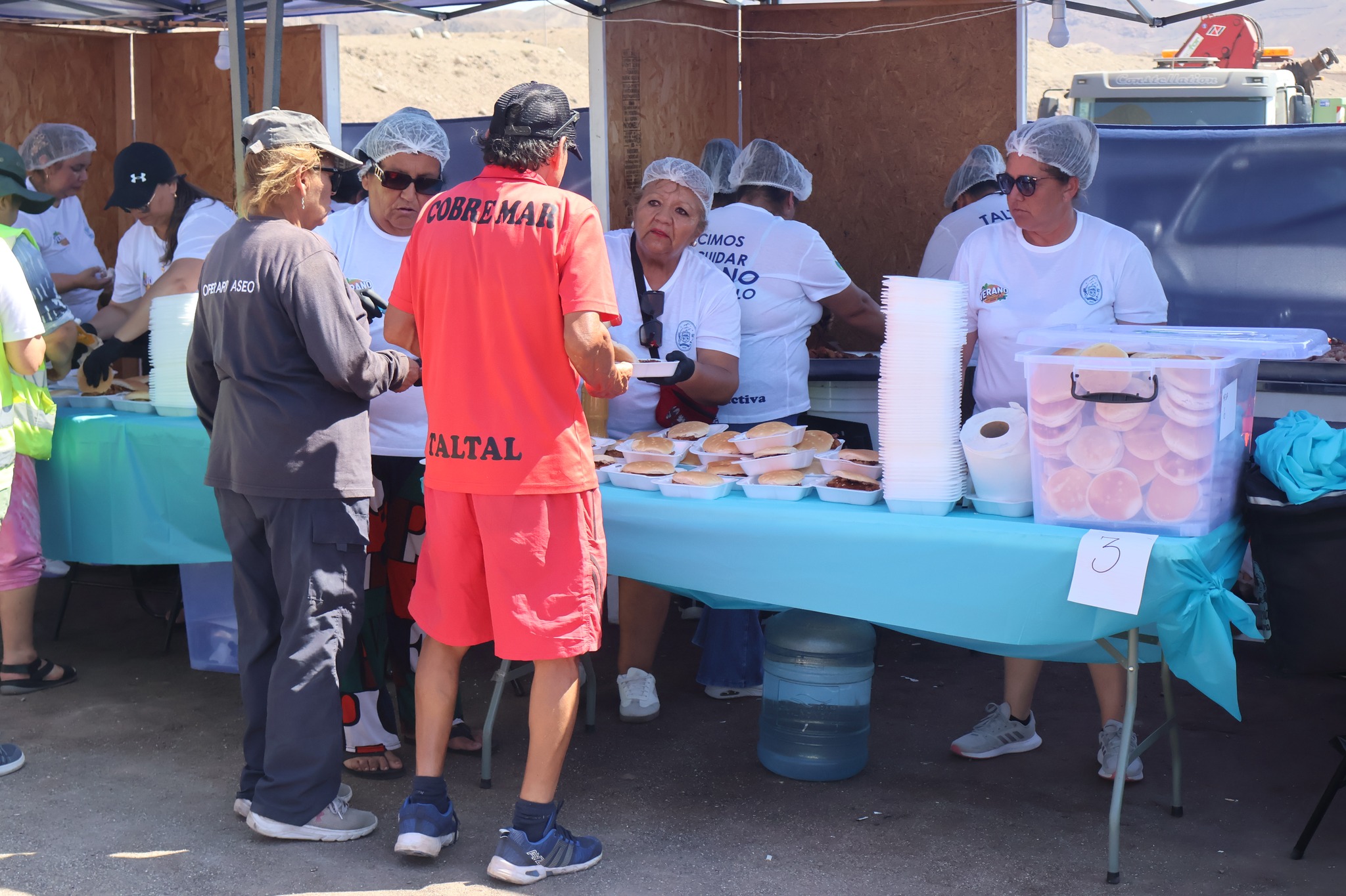 Entrega de sándwiches de pescado a asistentes durante la Gran Fritanga en Tierra del Moro, Taltal.