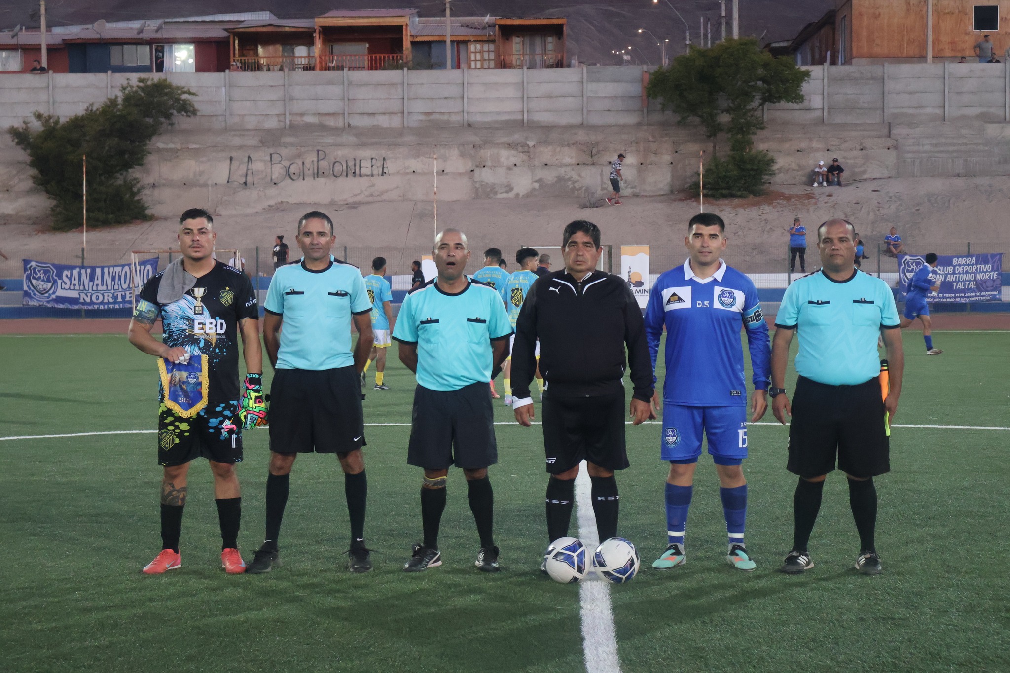 Árbitros y capitanes posan antes del partido en el Estadio Belmor Rojas Iriarte, Taltal.