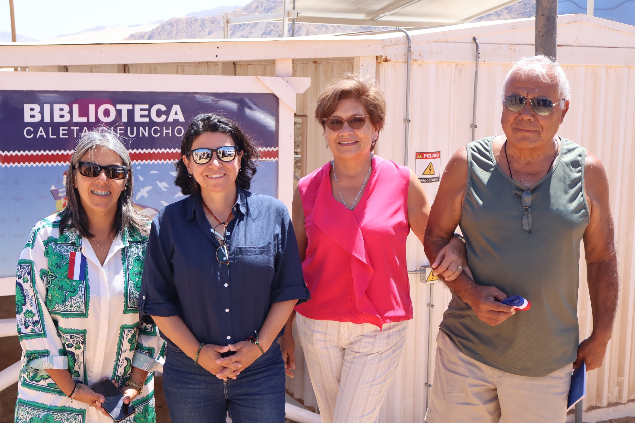 Autoridades posan frente al letrero de la Biblioteca Pública de Caleta Cifuncho, en actividad cultural en Taltal.