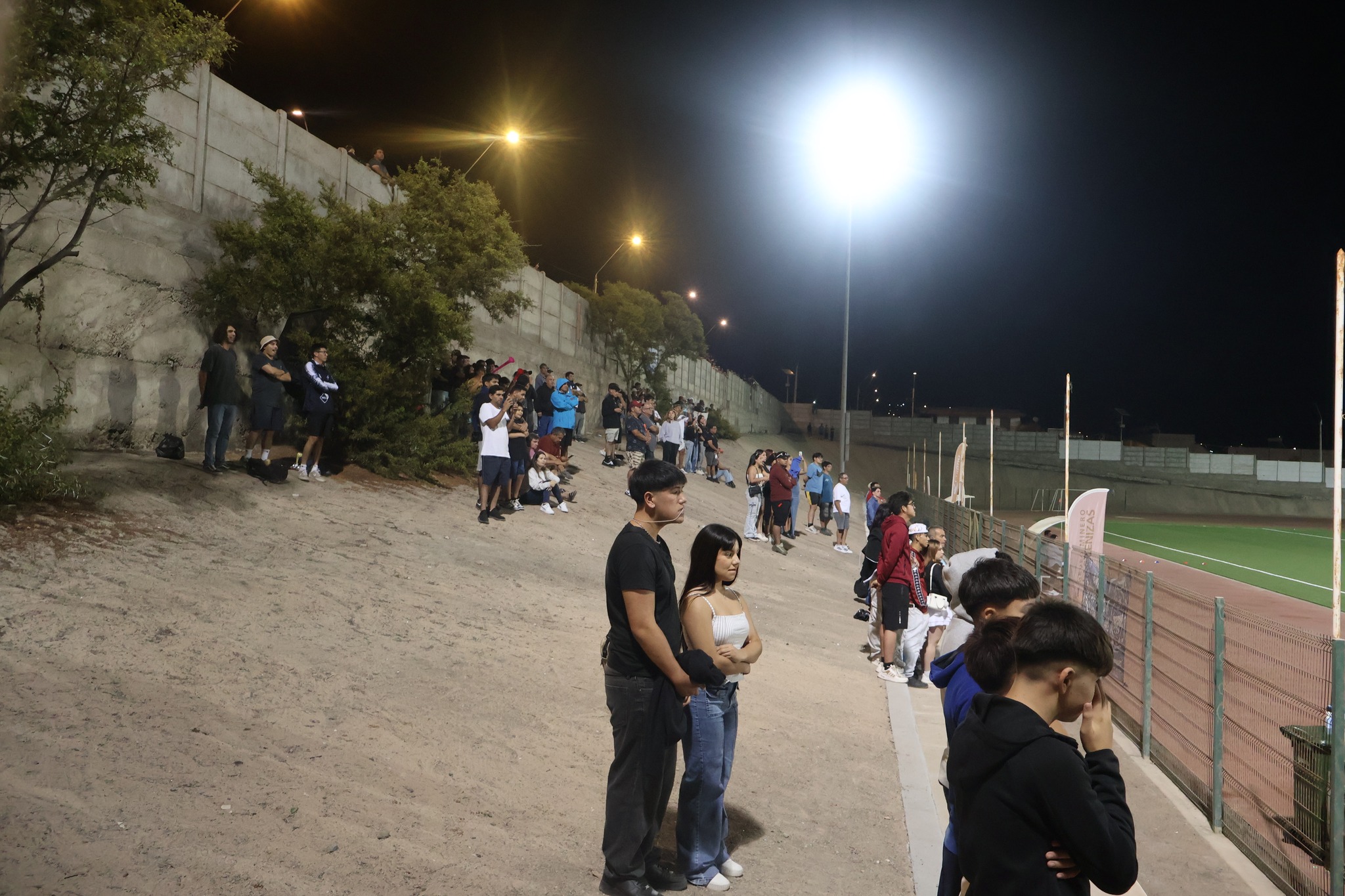 Espectadores observan la final del Torneo Zonal Norte ANFA 2026 desde la ladera del Estadio Belmor Rojas Iriarte de Taltal.