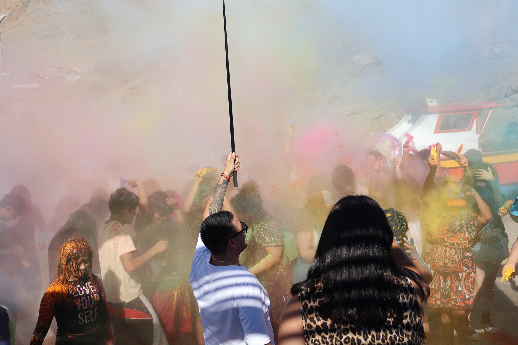 Niños y adultos cubiertos por una gran nube de polvos amarillos durante el sunset en Paposo.